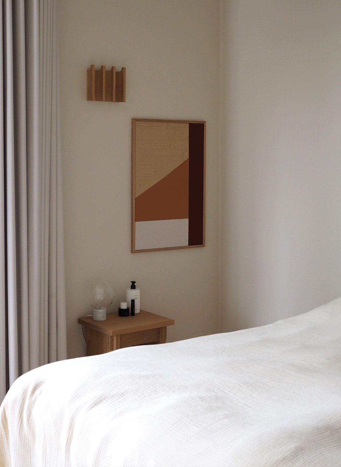 Framed minimalistic poster hanging in bedroom by Atelier Cph