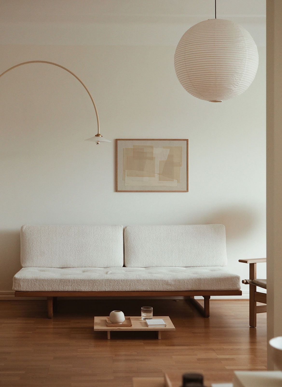 Framed minimalistic poster hanging above a couch by Atelier Cph