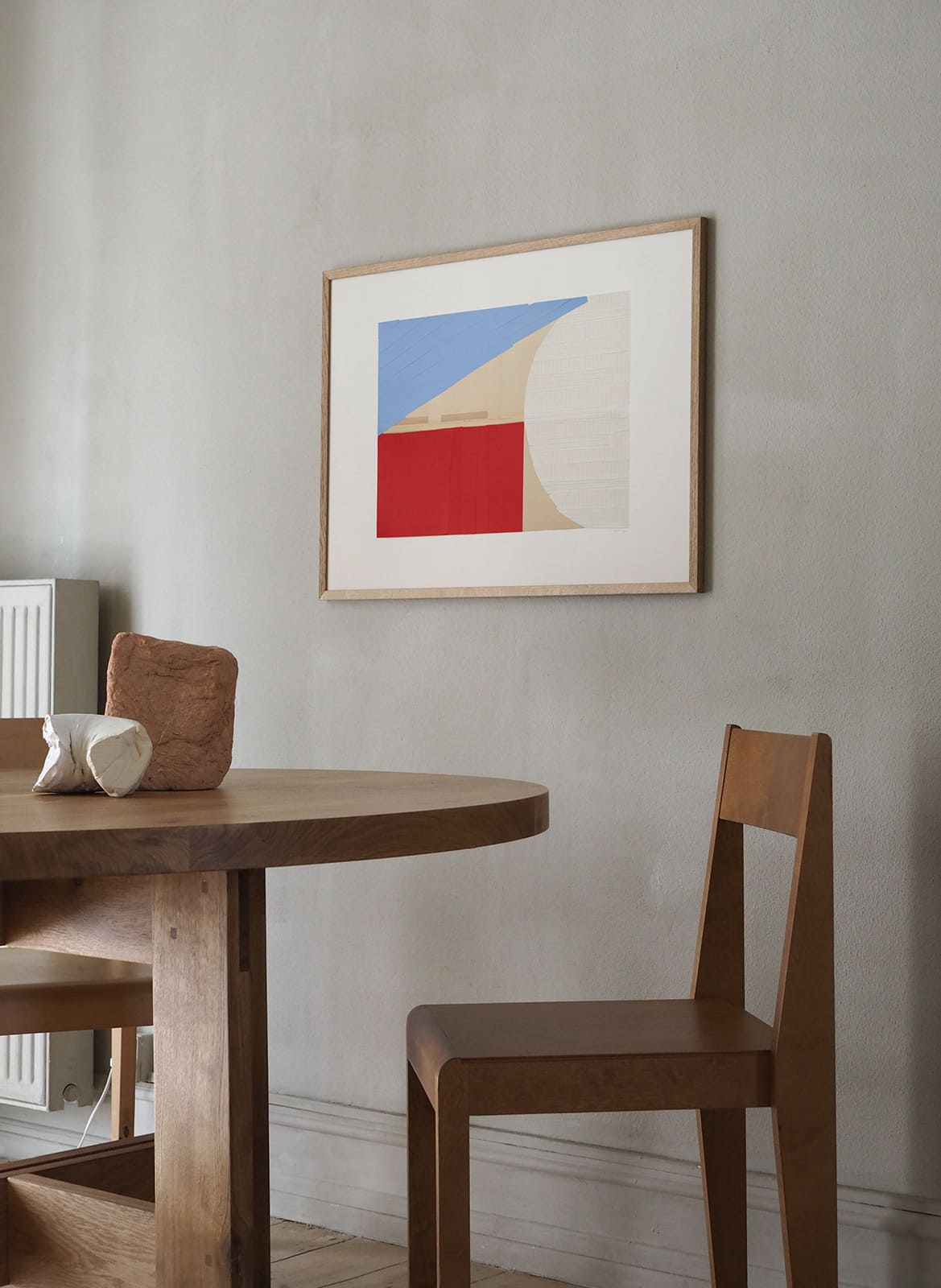  Framed colourful poster hanging above dining table by Atelier Cph