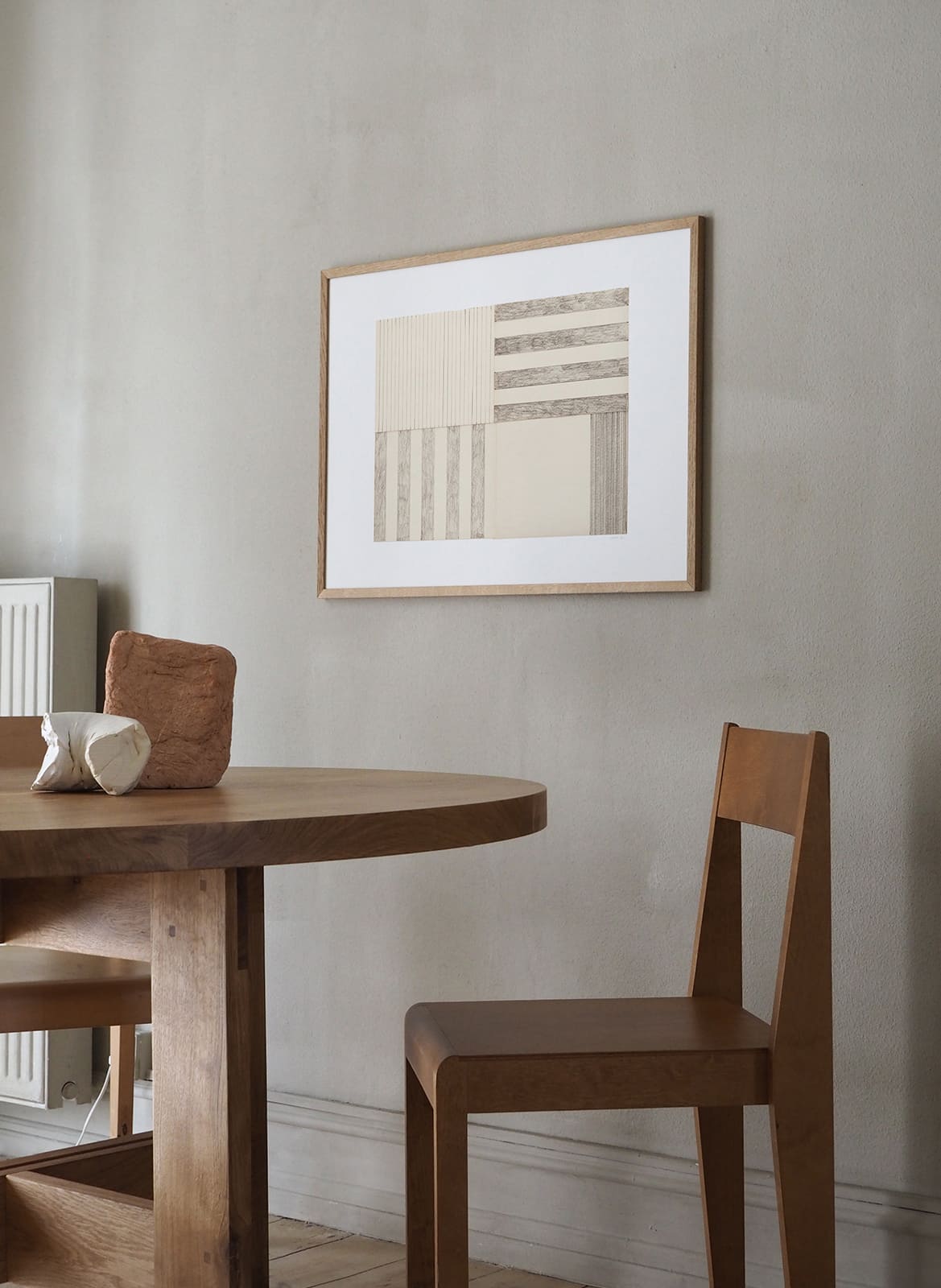Framed minimalistic posters hanging above a table by Atelier Cph