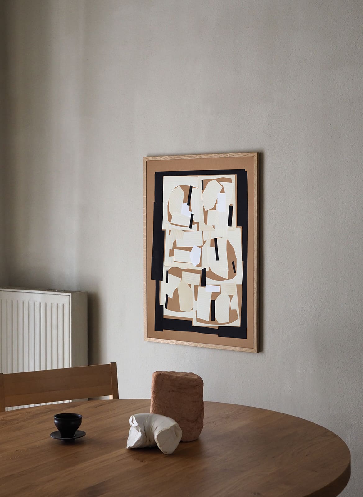 Framed minimalistic poster hanging above dining table by Atelier Cph