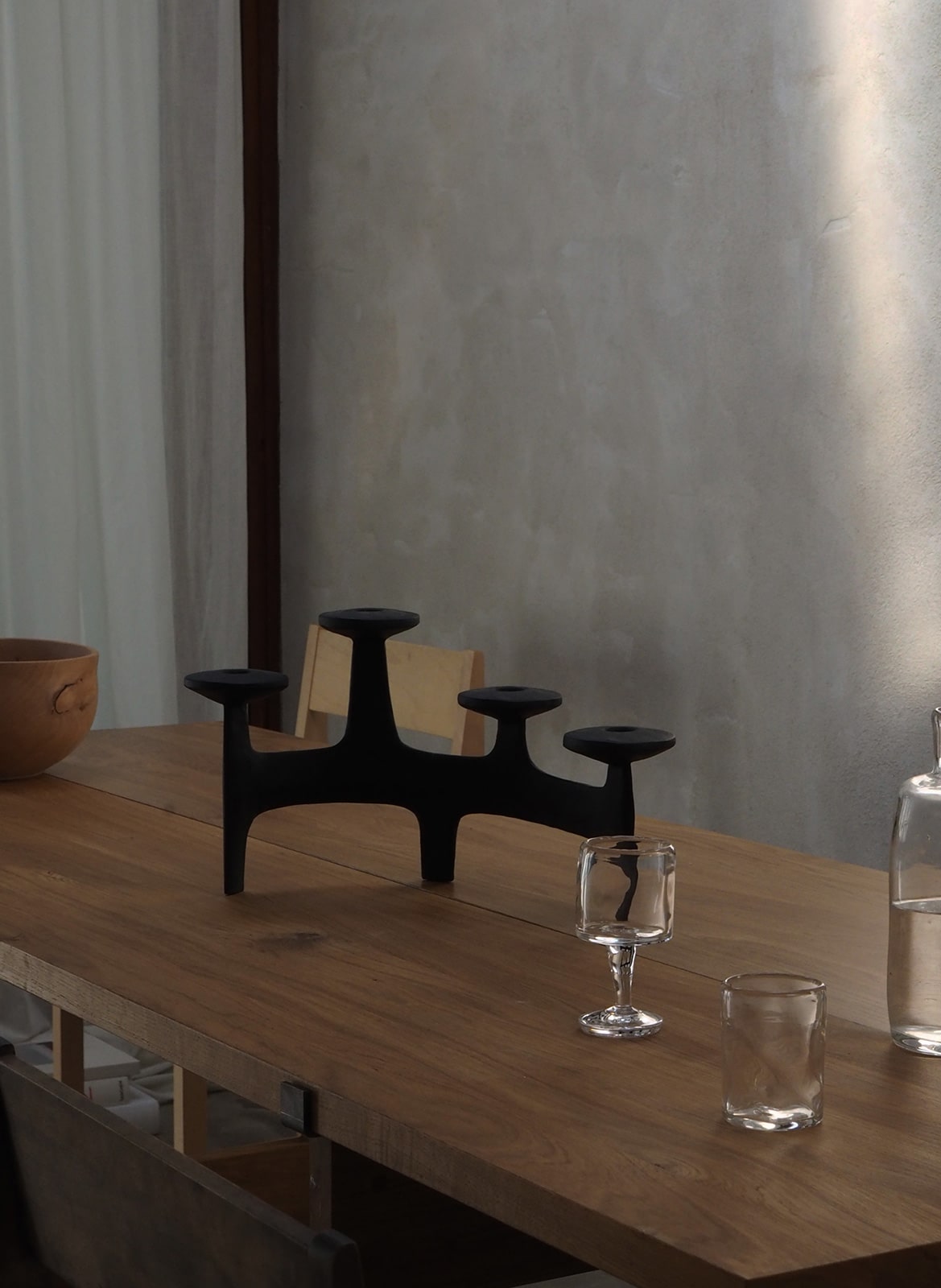Black sculptural iron candelabra standing on table designed by Anderssen & Voll