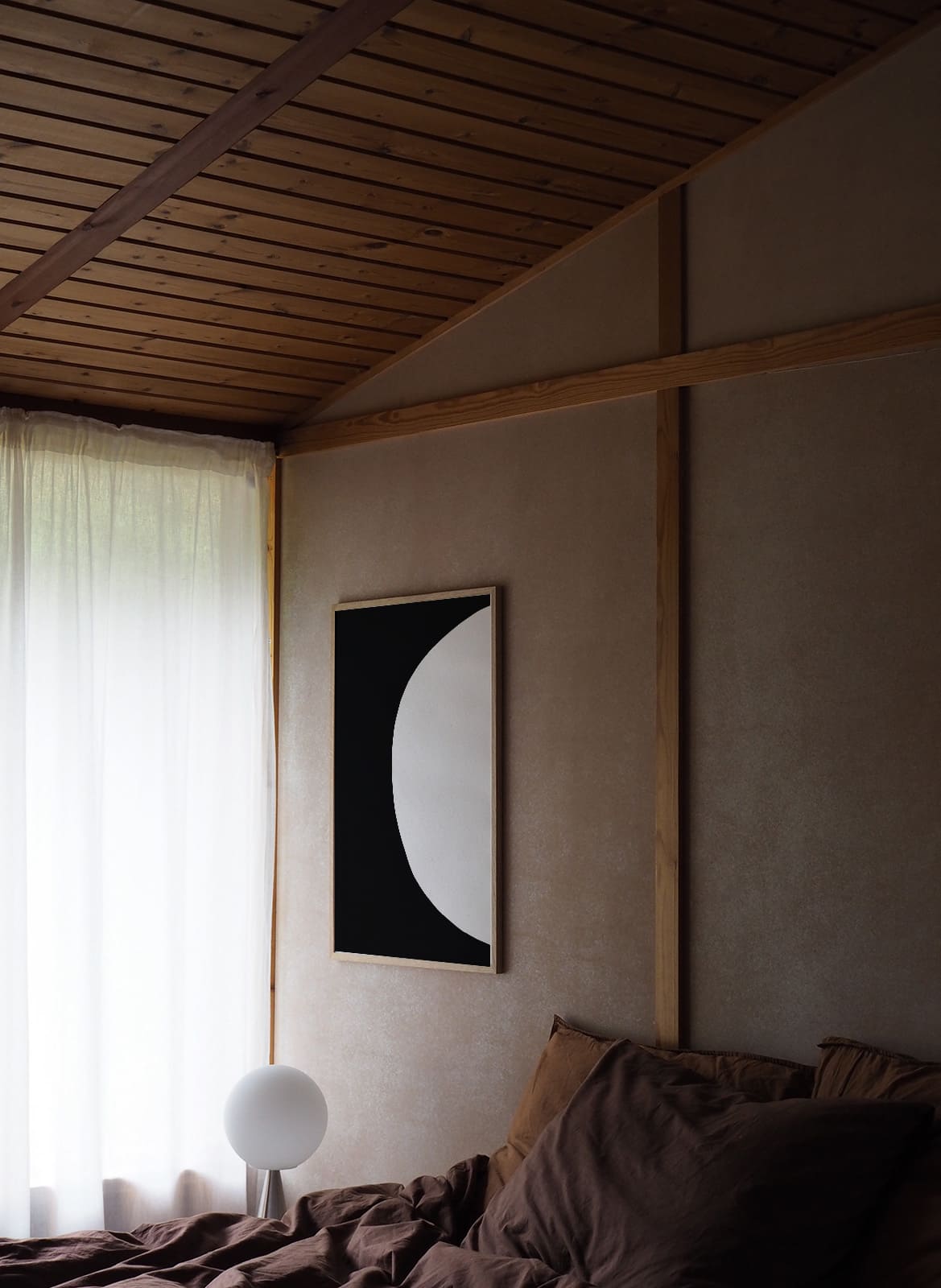 Framed black and white poster hanging above a bed by Atelier Cph