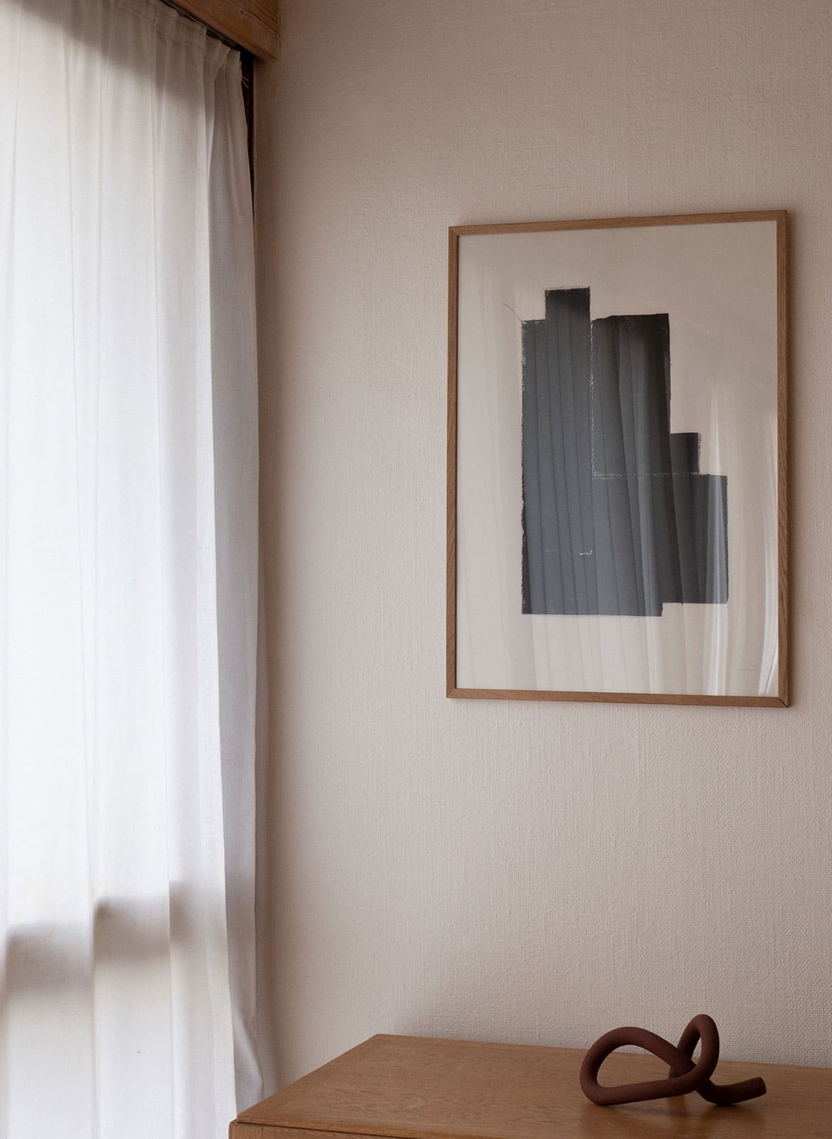Framed black and white poster hanging above a table by Atelier Cph