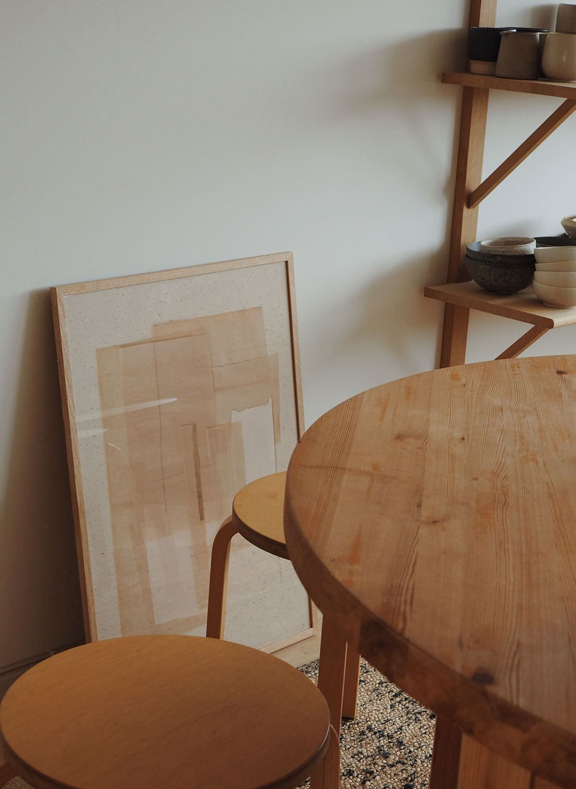 Beige minimalistic poster standing behind a kitchen table by atelier cph