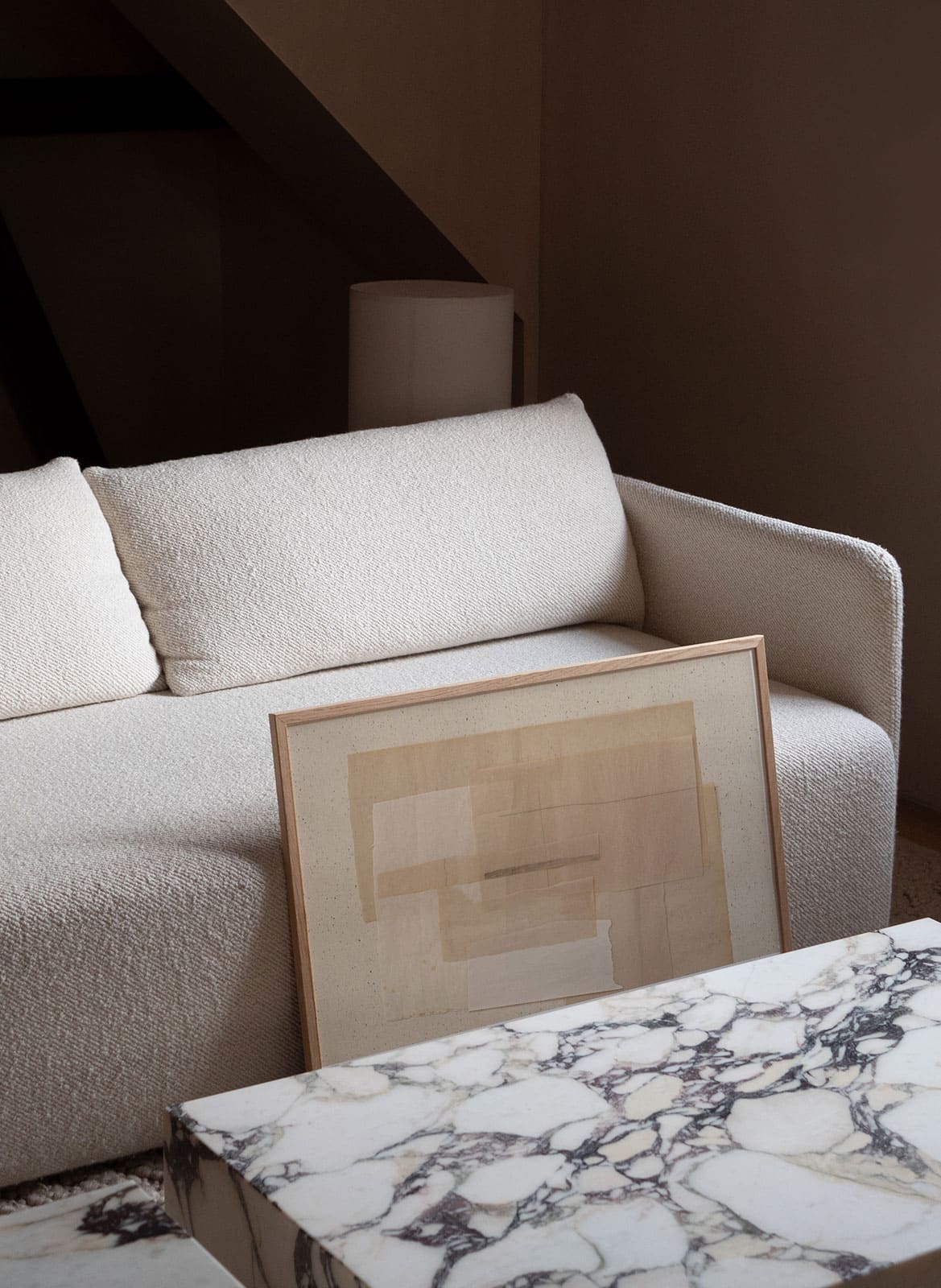 Beige minimalistic poster standing in a living room by atelier cph