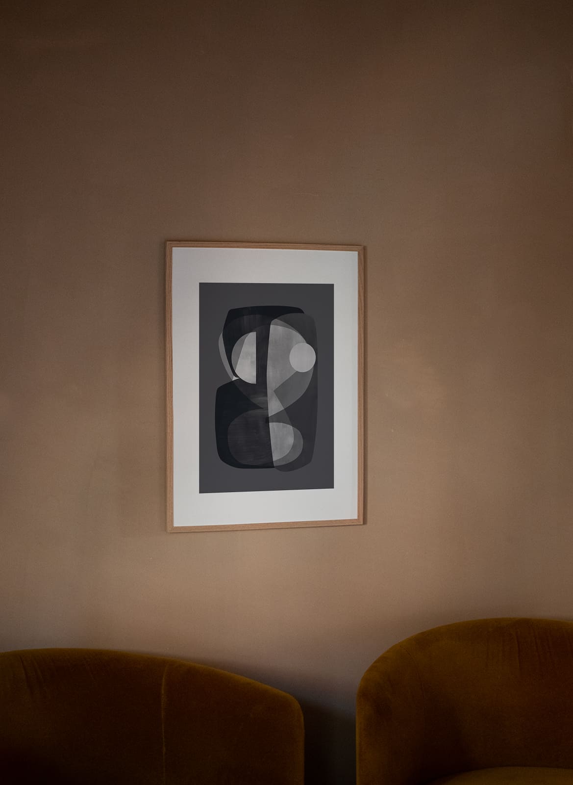 Framed abstract grey poster hanging above a couch by Atelier Cph