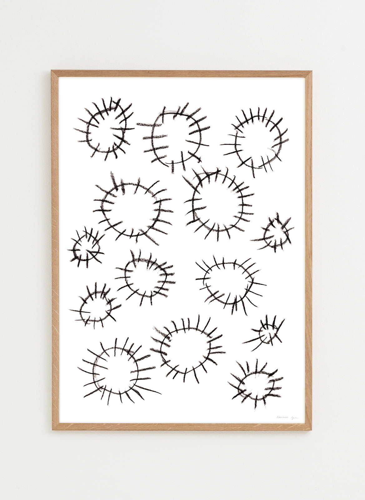 Framed artwork with black abstract circular patterns on a white background