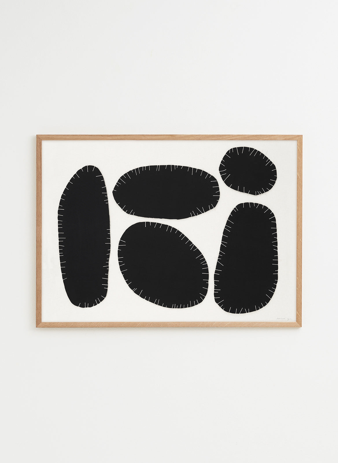 Framed abstract art with black shapes on a white background