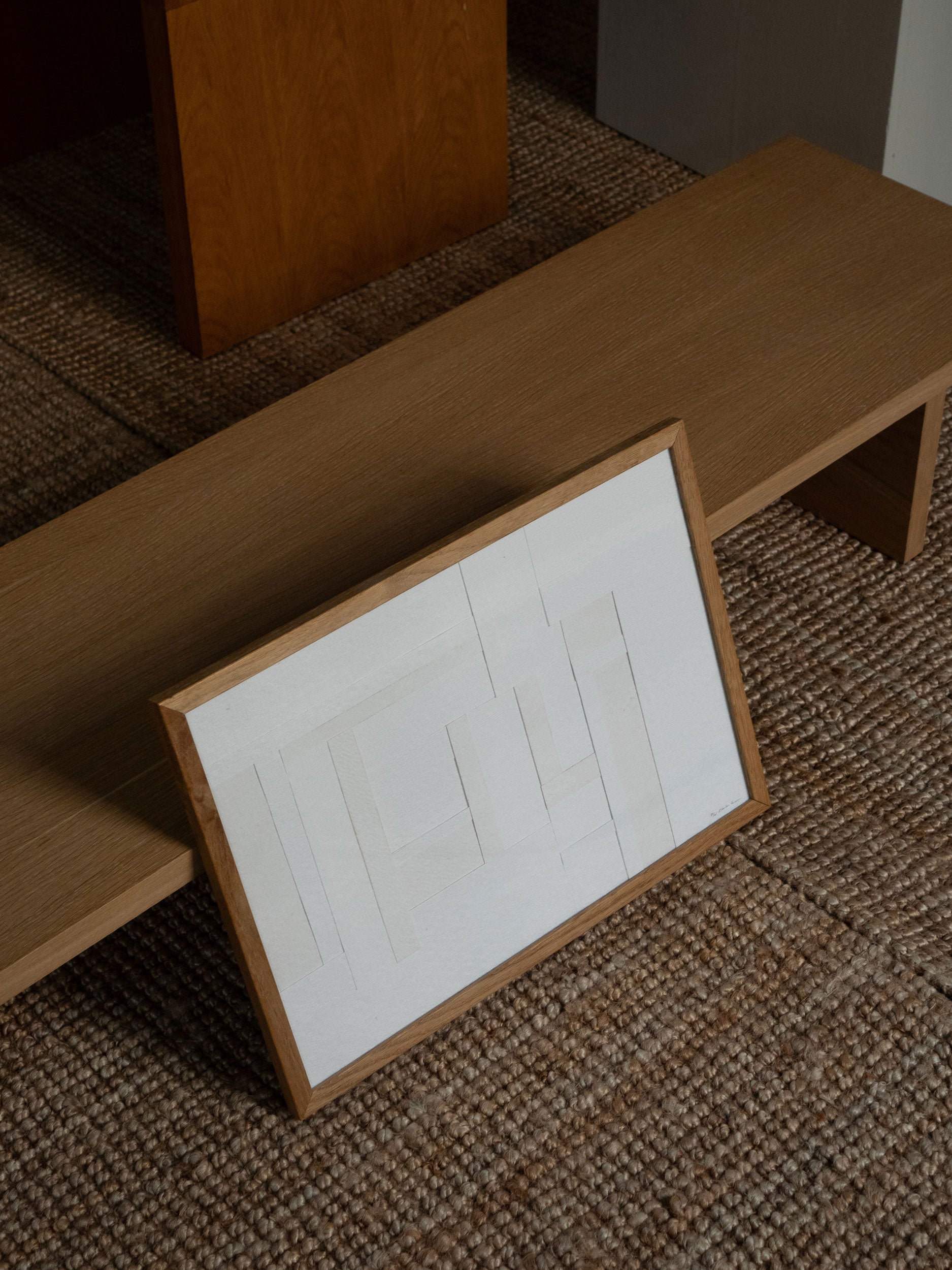 Minimalist white paper collage with layered geometric shapes in a light oak frame, created as a limited edition by Atelier Cph.