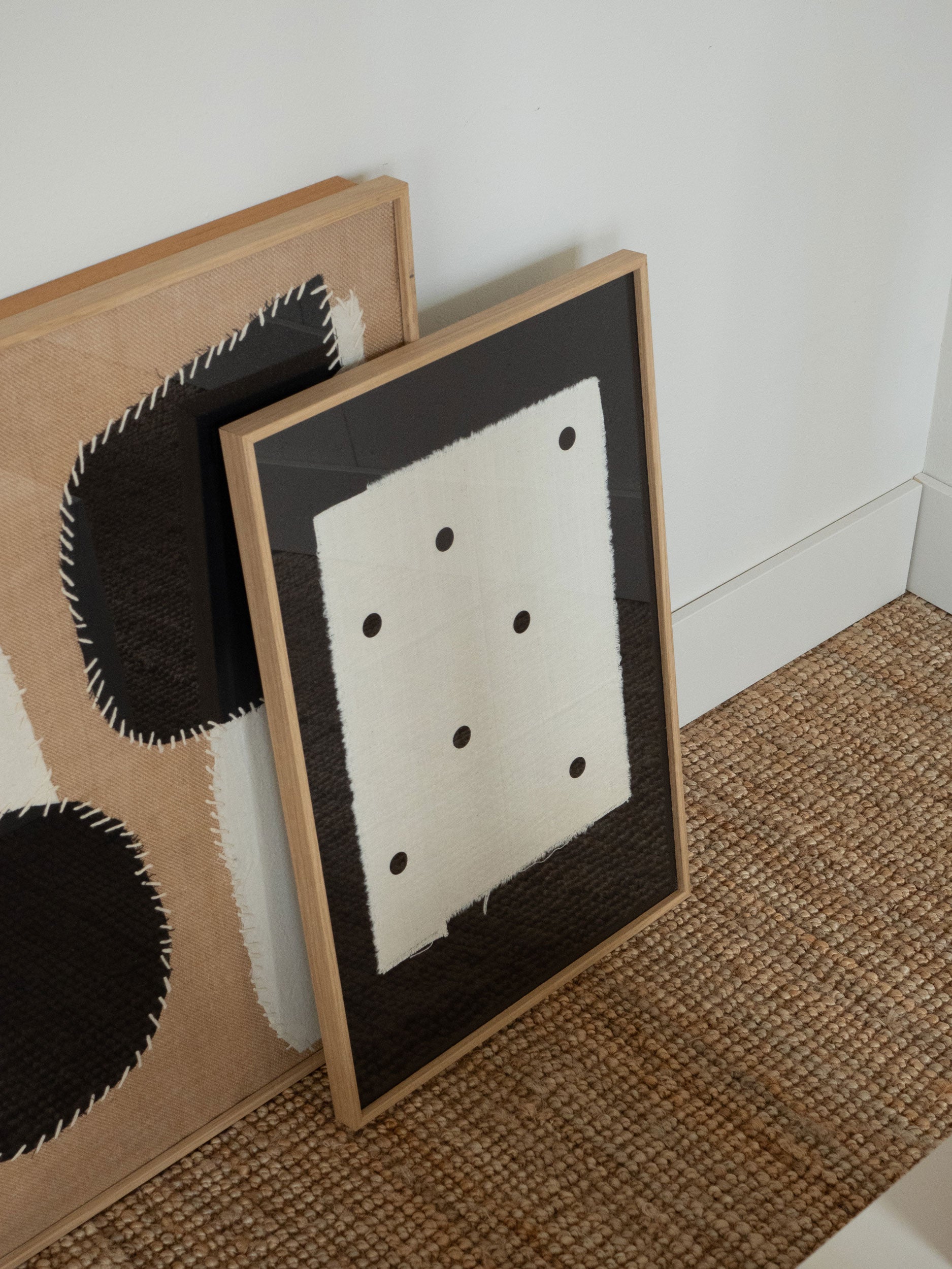 Minimalist black artwork with sand-coloured fabric and black dots, featuring frayed textile edges on a dark background, created by Atelier Cph as a limited edition art piece.