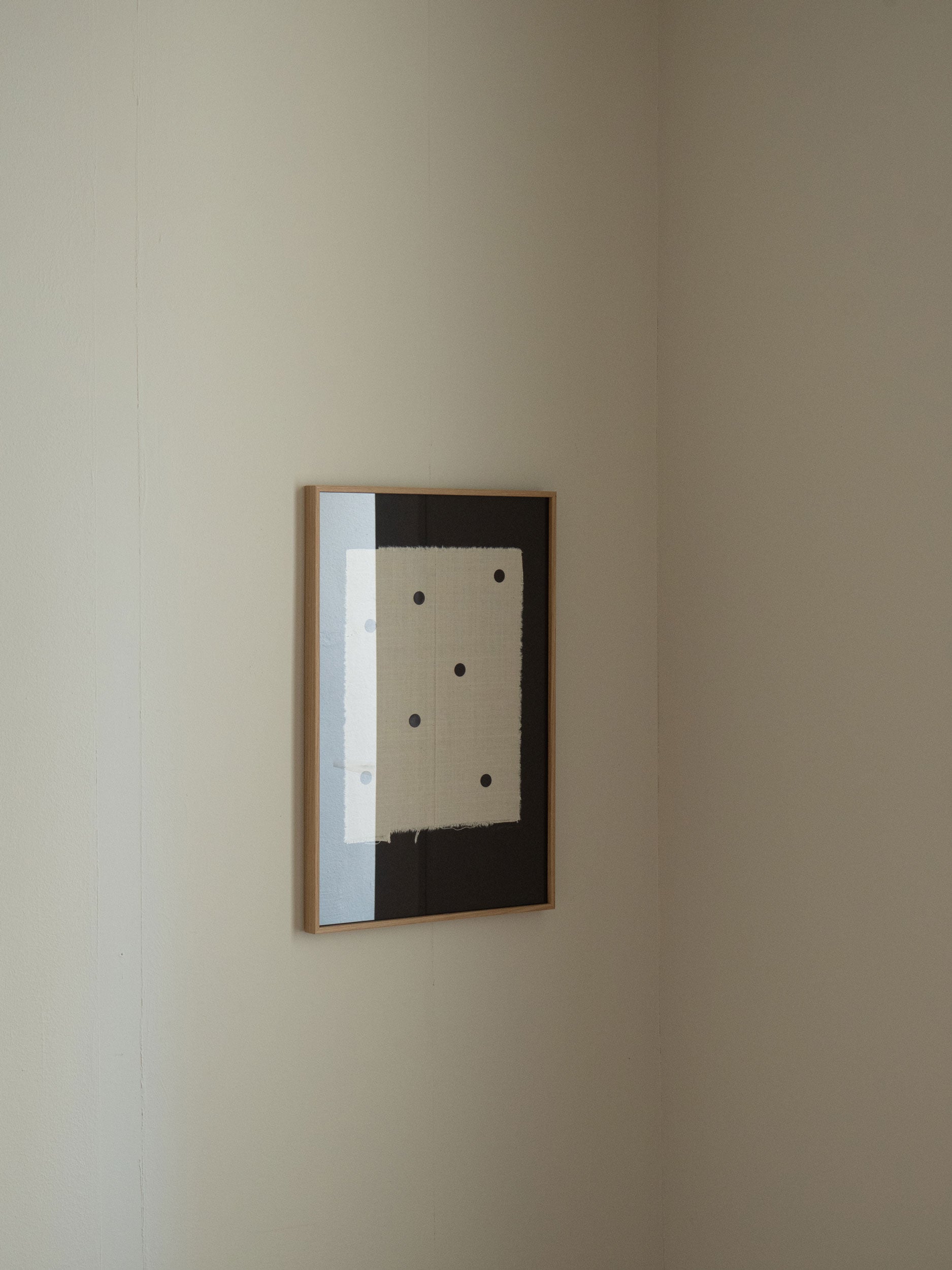 Minimalist black artwork with sand-coloured fabric and black dots, featuring frayed textile edges on a dark background, created by Atelier Cph as a limited edition art piece.