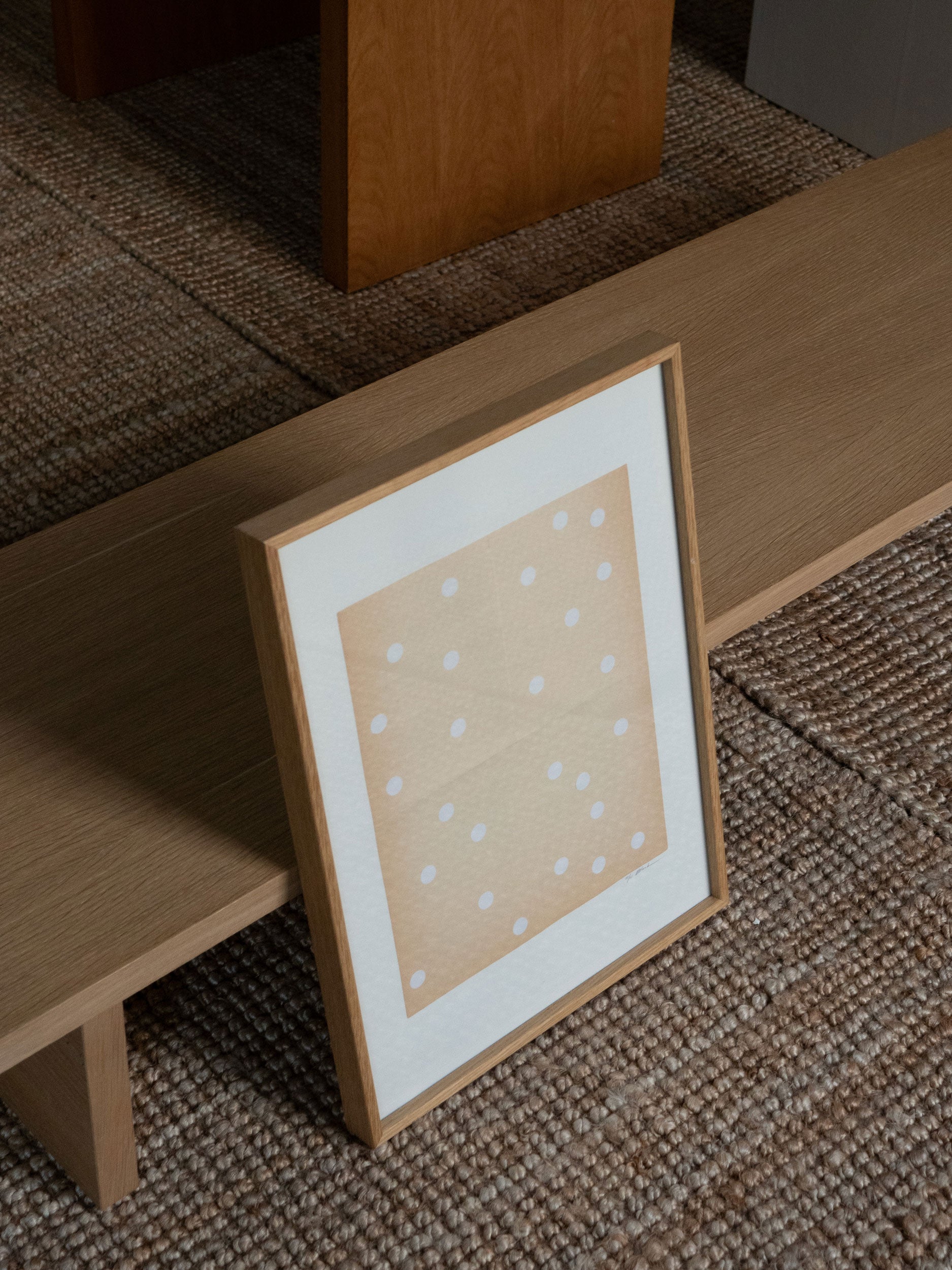 Minimalist sand-coloured artwork with white dots on textured paper, framed in solid oak and created as a limited edition by Atelier Cph.