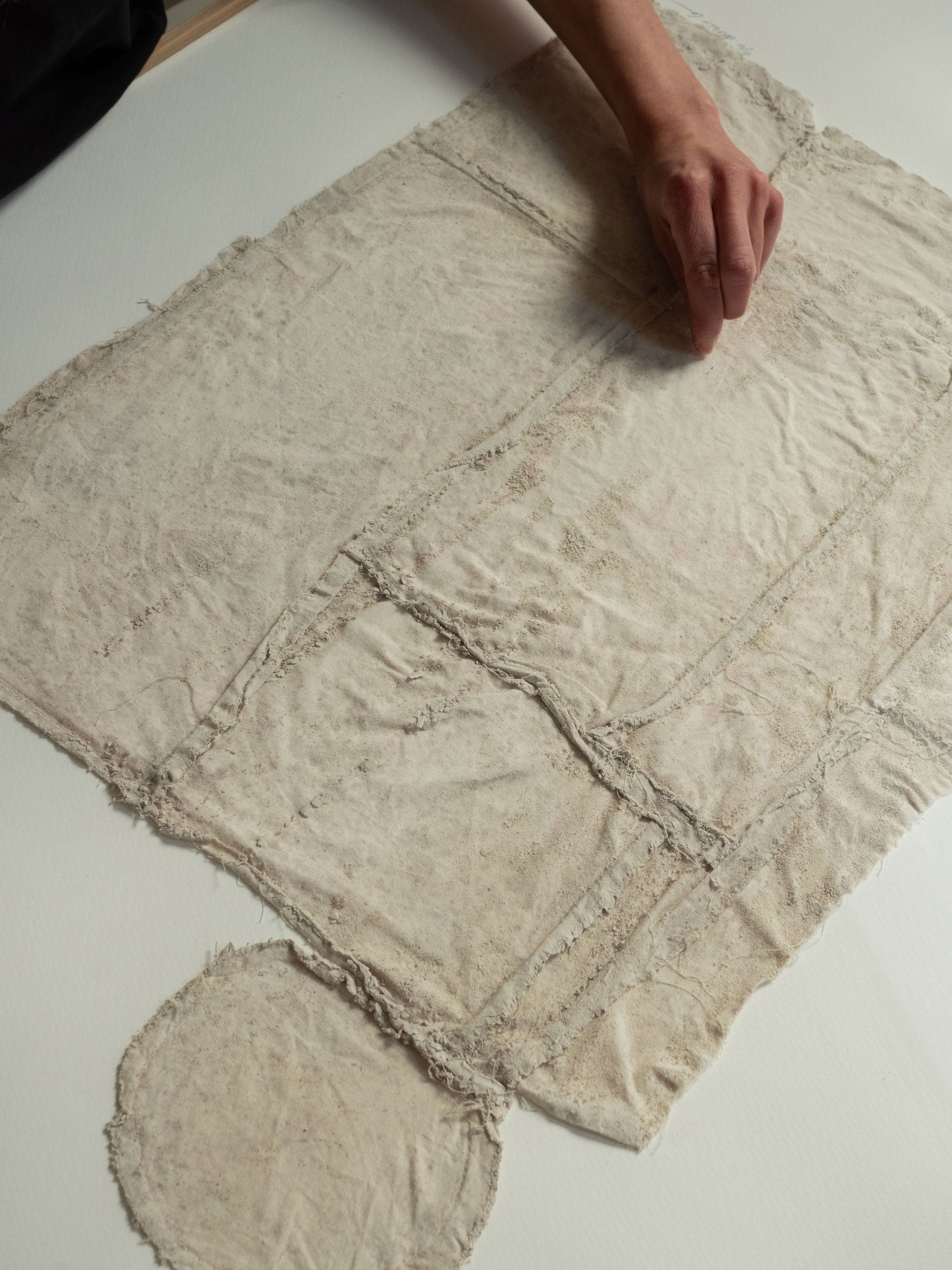 Textured beige fabric on a white surface by atelier cph