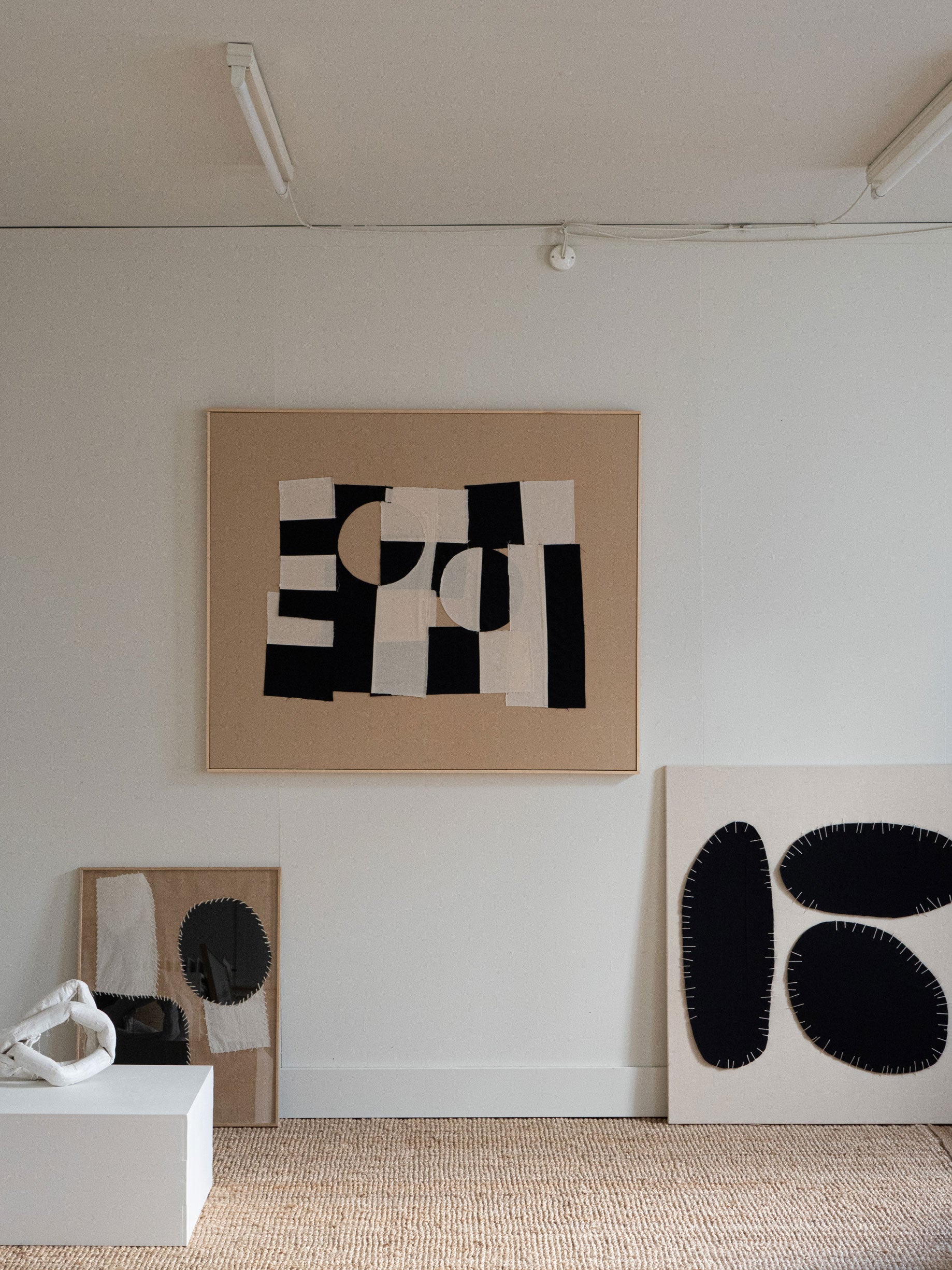 Abstract art pieces on a white wall with a neutral color palette all made by Atelier Cph