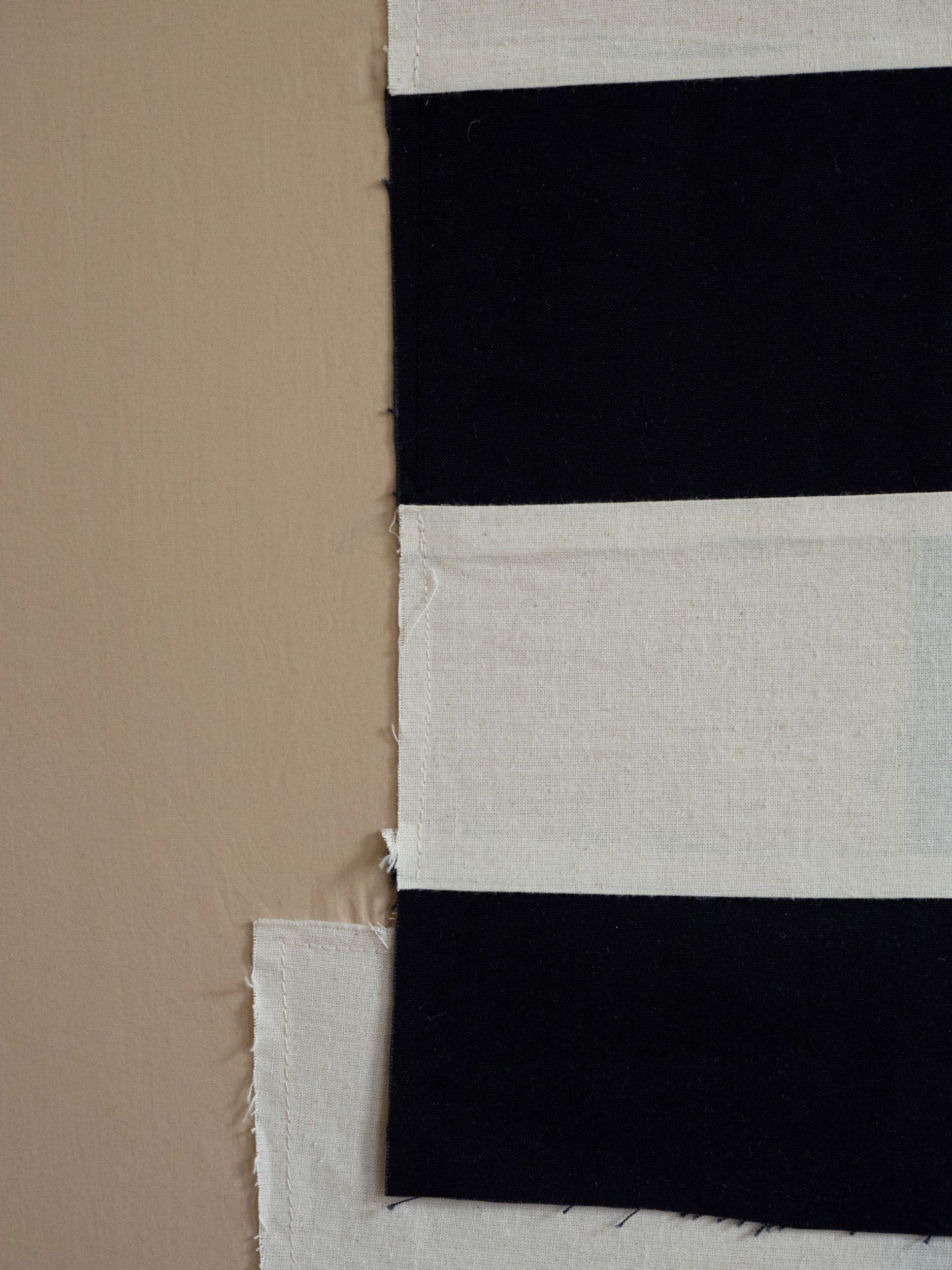 Close-up of a fabric with black and white stripes on a beige background by Atelier Cph