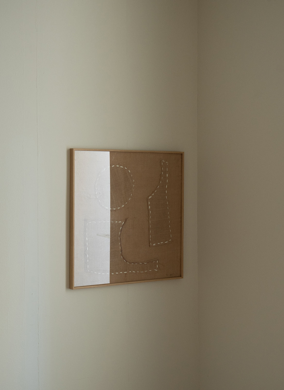 Framed abstract artwork on a beige wall by atelier cph