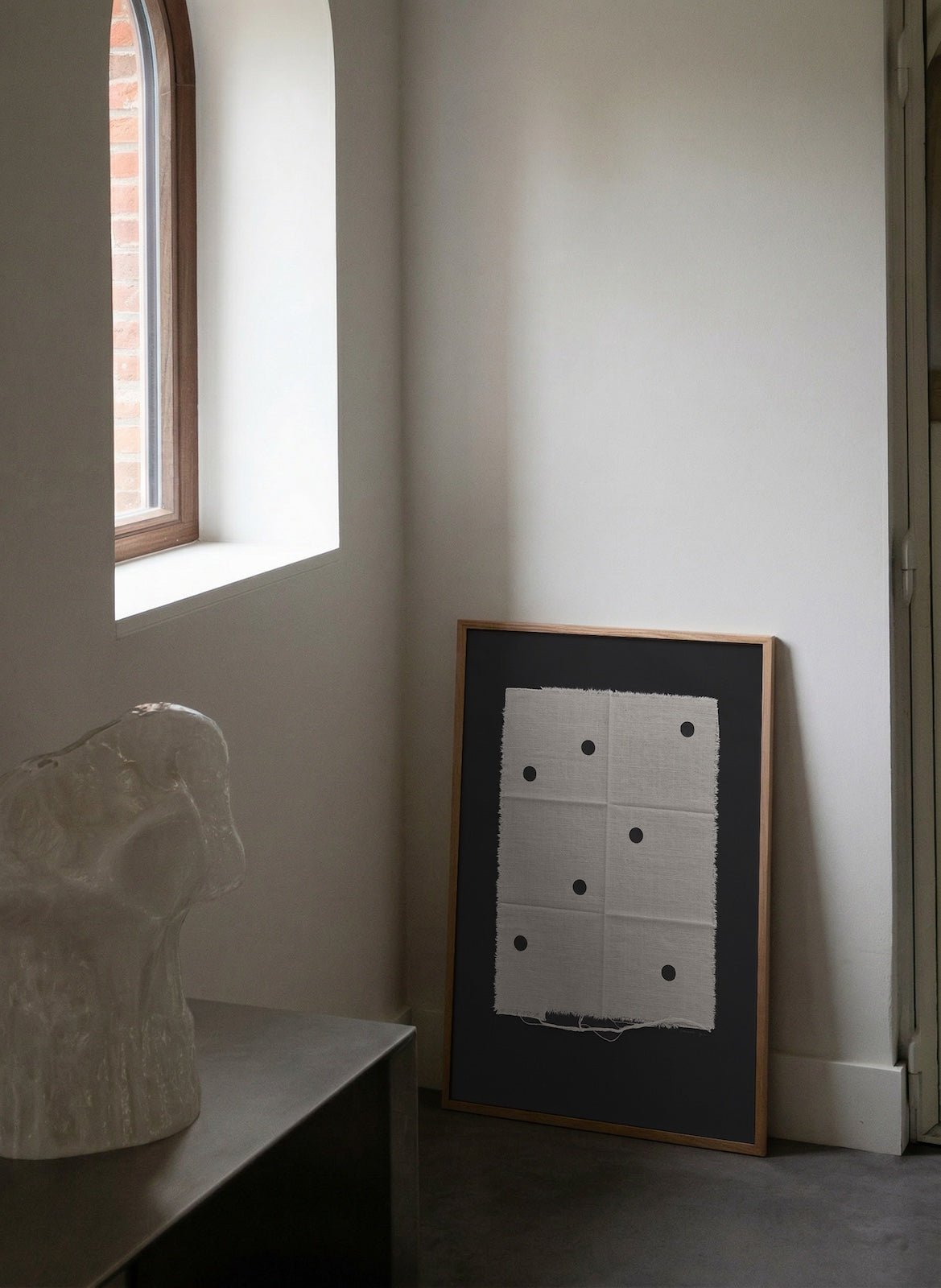 Framed artwork on a wall next to a window with natural light