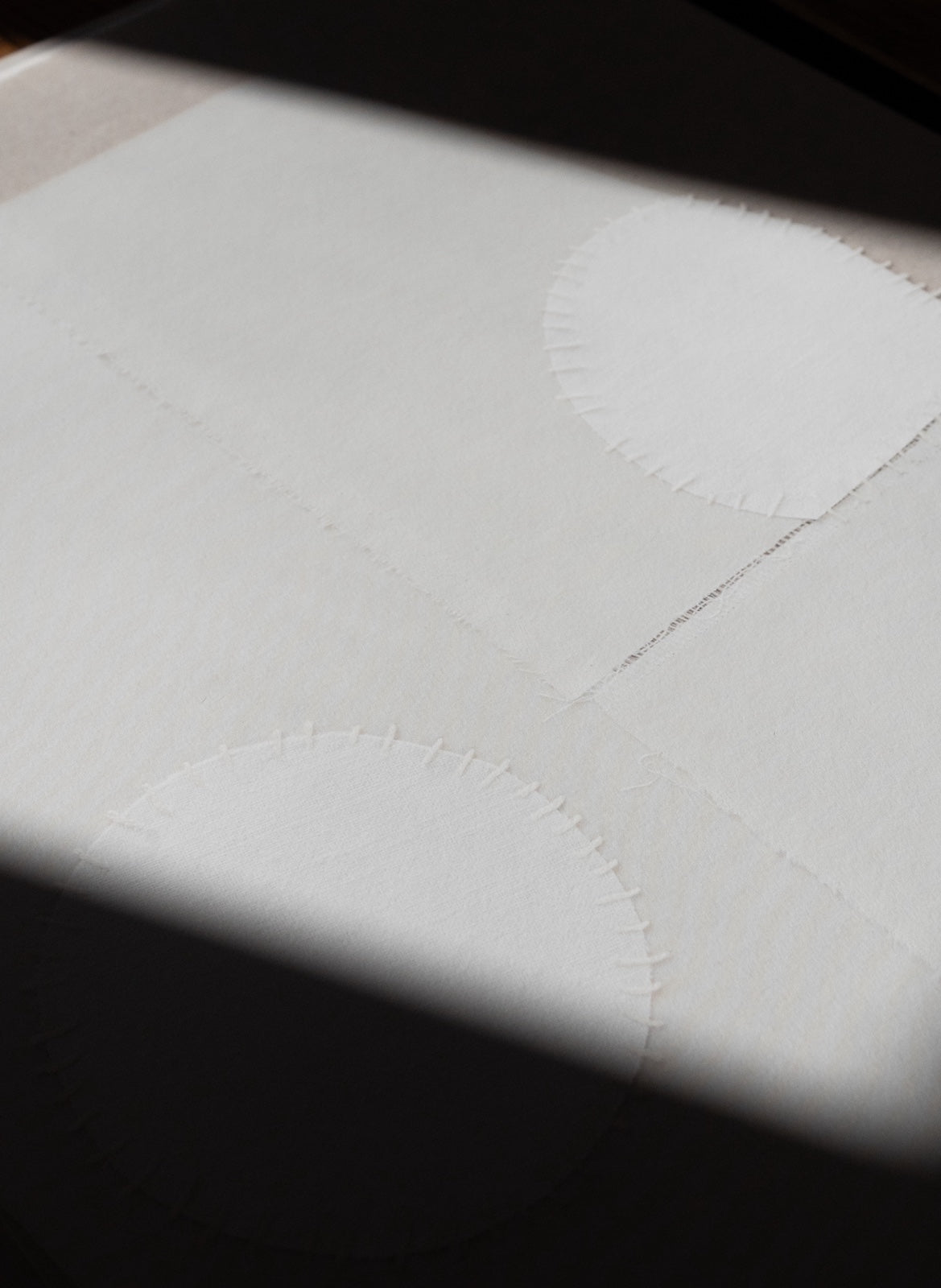 Close-up of a textured white surface with stitching details