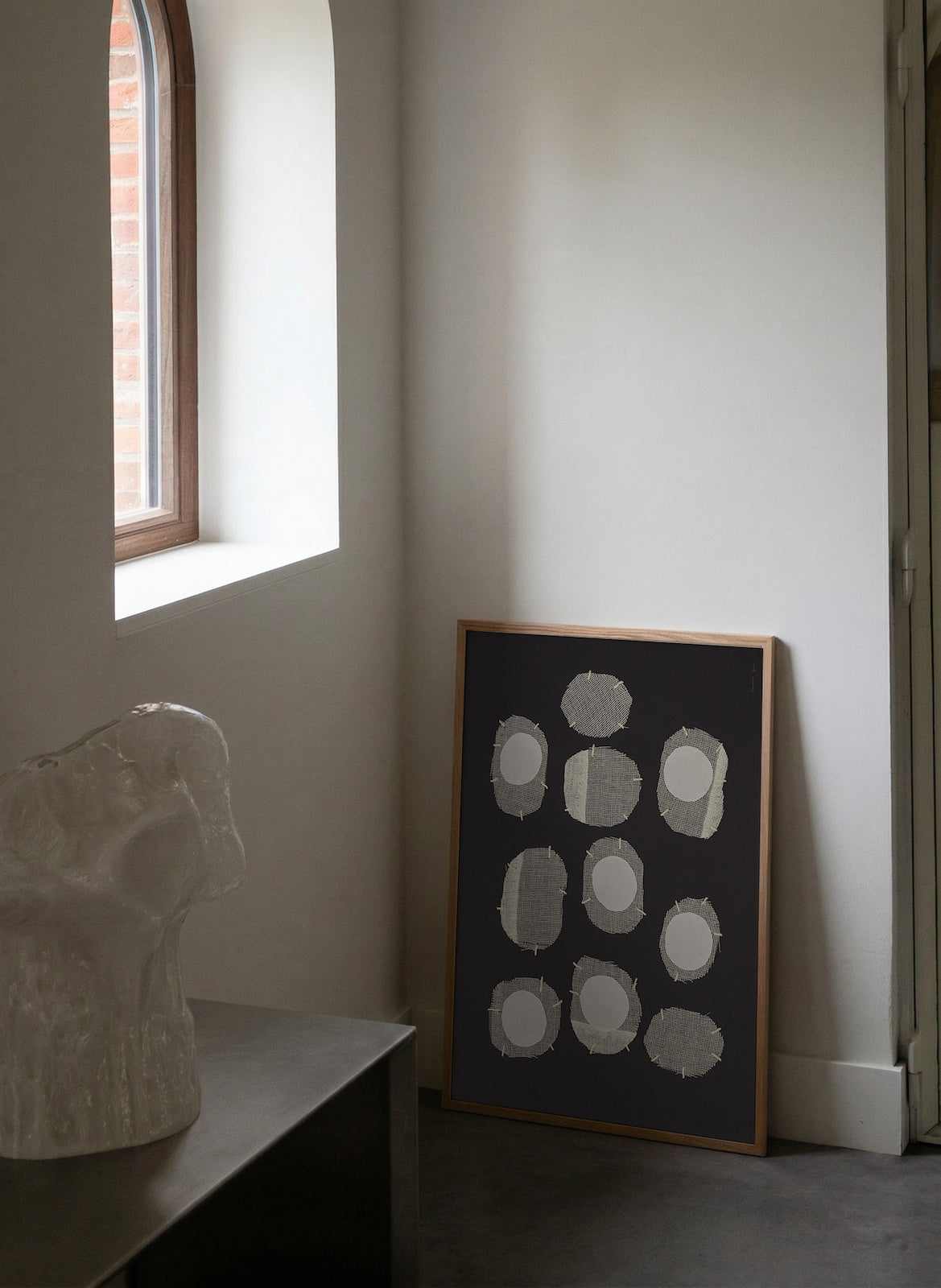 Abstract art piece on a wall next to a window with natural light.