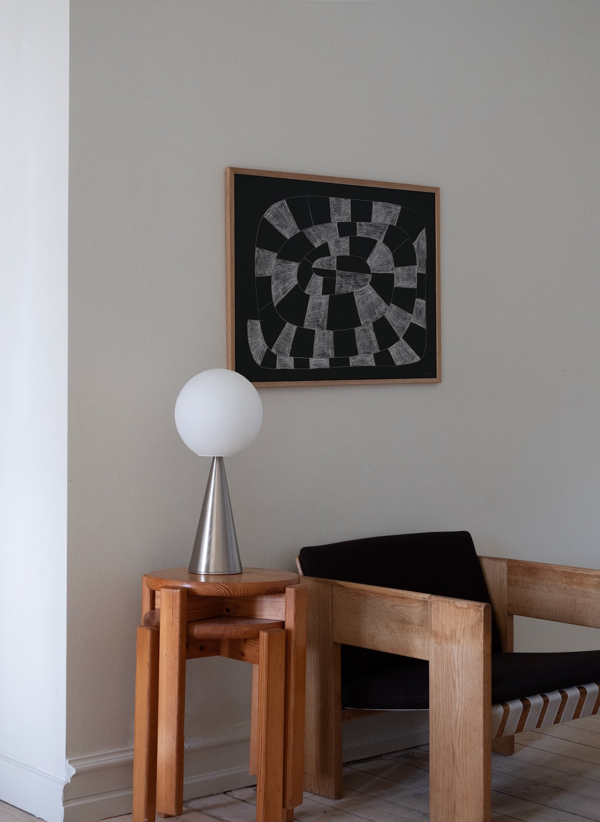 Modern interior with wooden chair, side table, and abstract art on the wall.