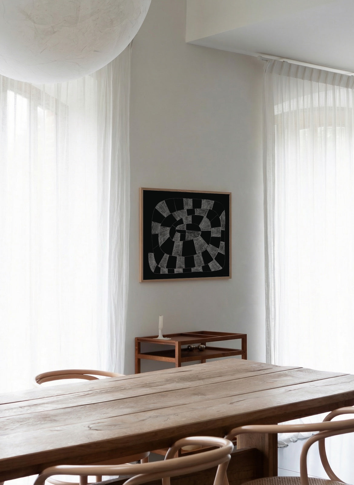 Modern dining room with wooden table and chairs, abstract art on the wall.