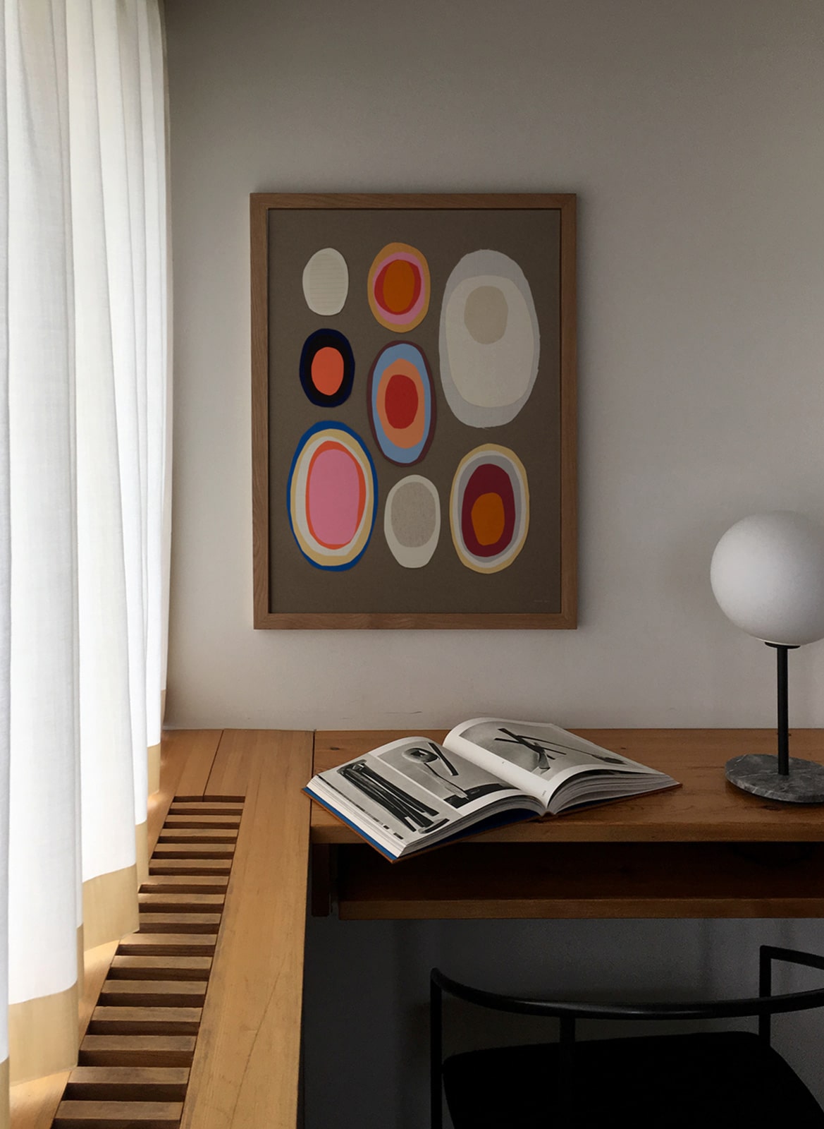 Framed colorful pink poster hanging in a living room by Atelier Cph