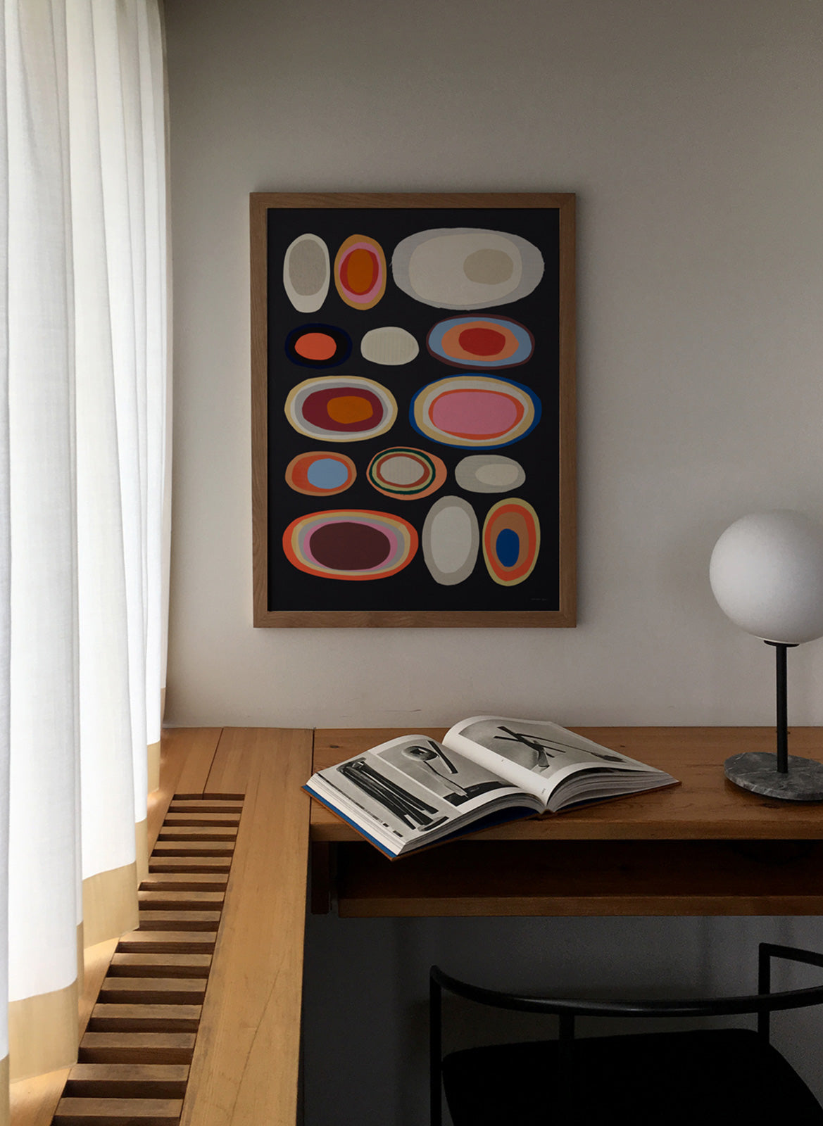 Framed colorful poster hanging in a living room by Atelier Cph