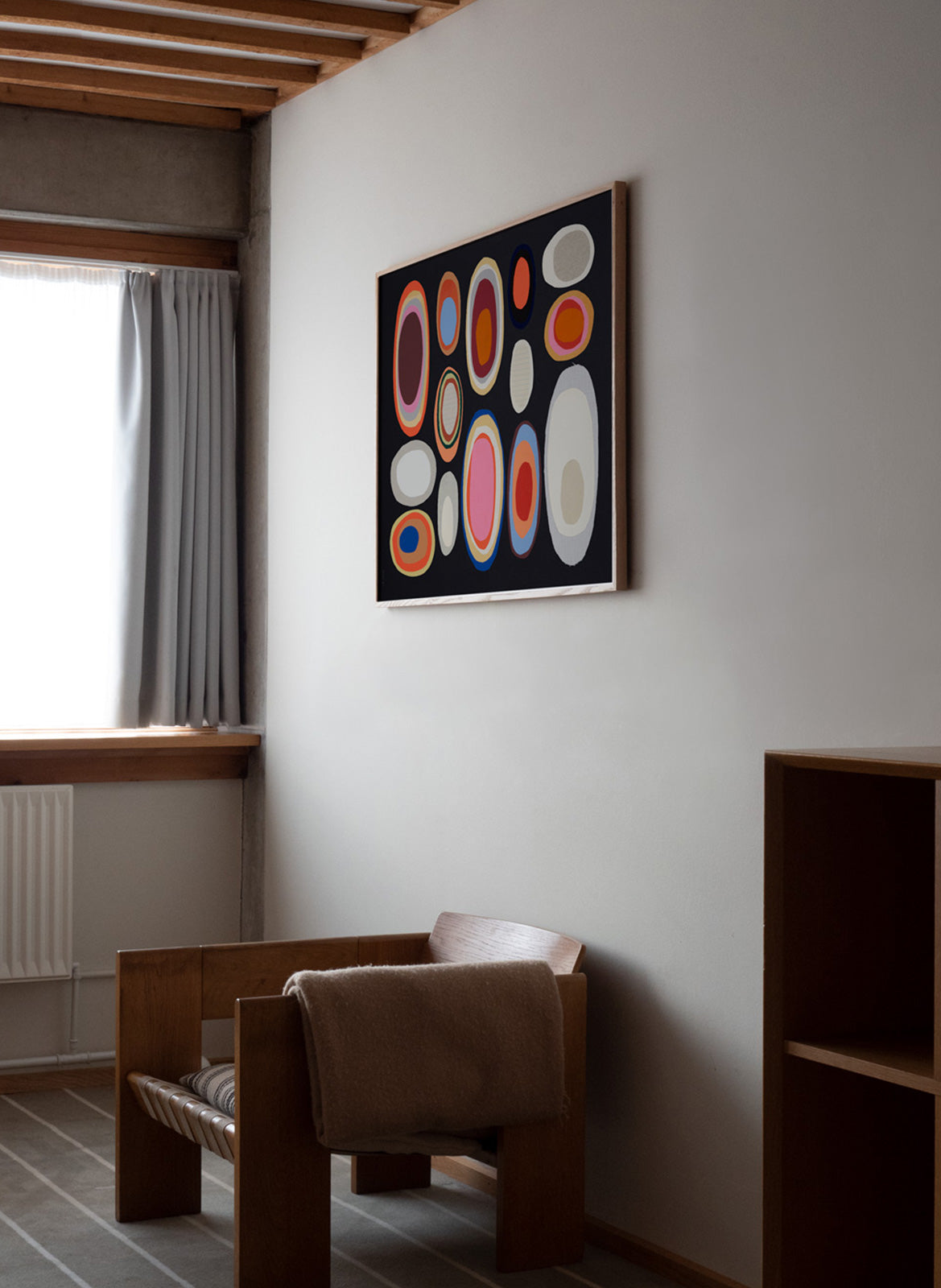 Framed colorful poster hanging in a living room by Atelier Cph