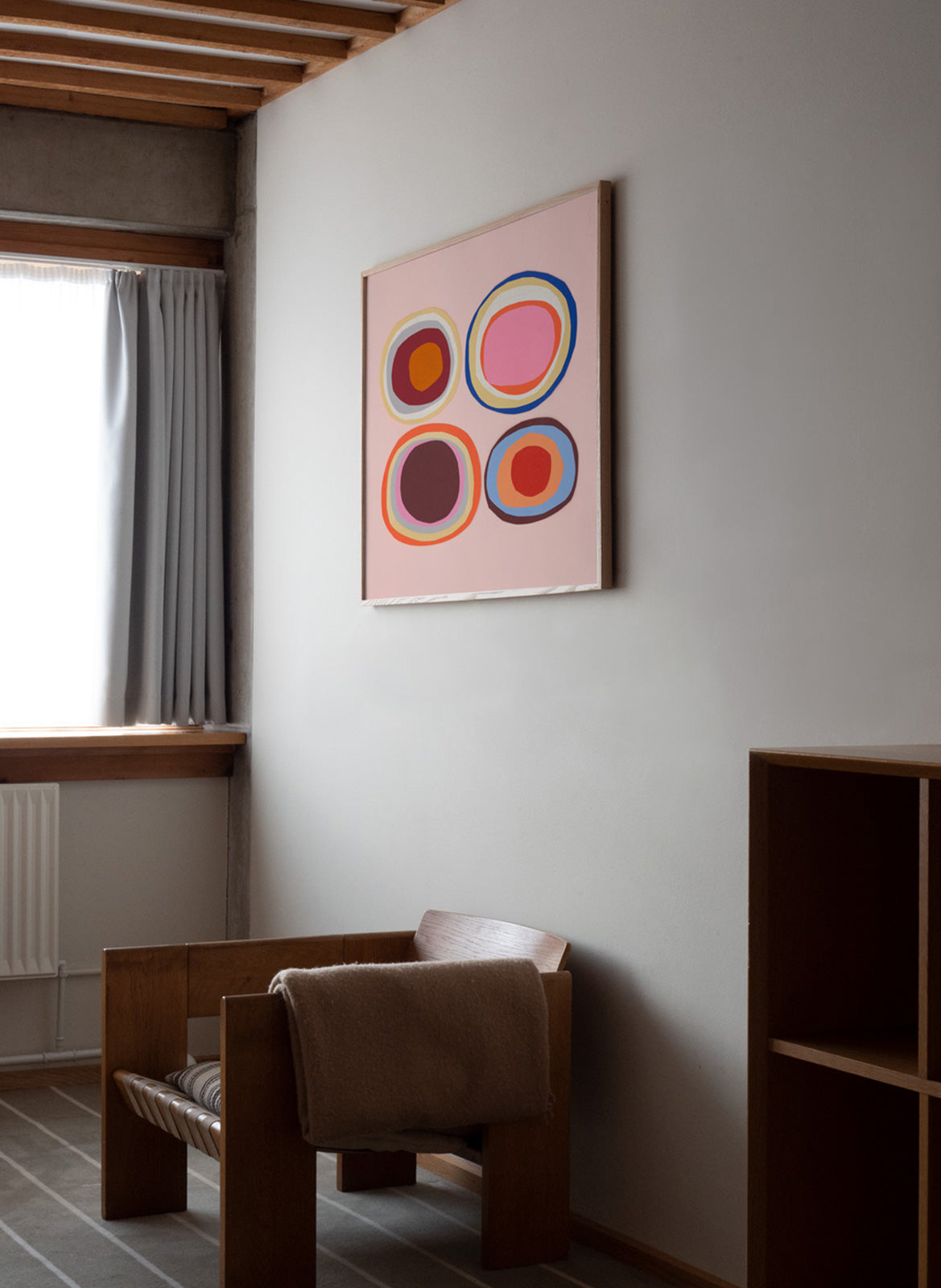 Framed colorful pink poster hanging in a living room by Atelier Cph