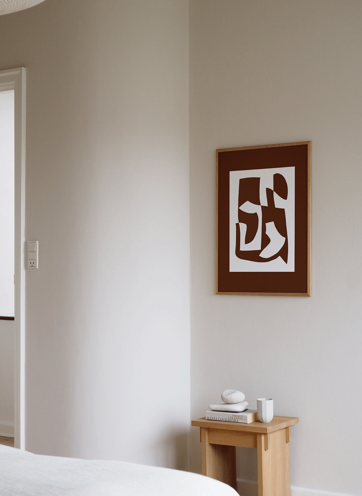 Framed minimalistic poster hanging in a bedroom by Atelier Cph