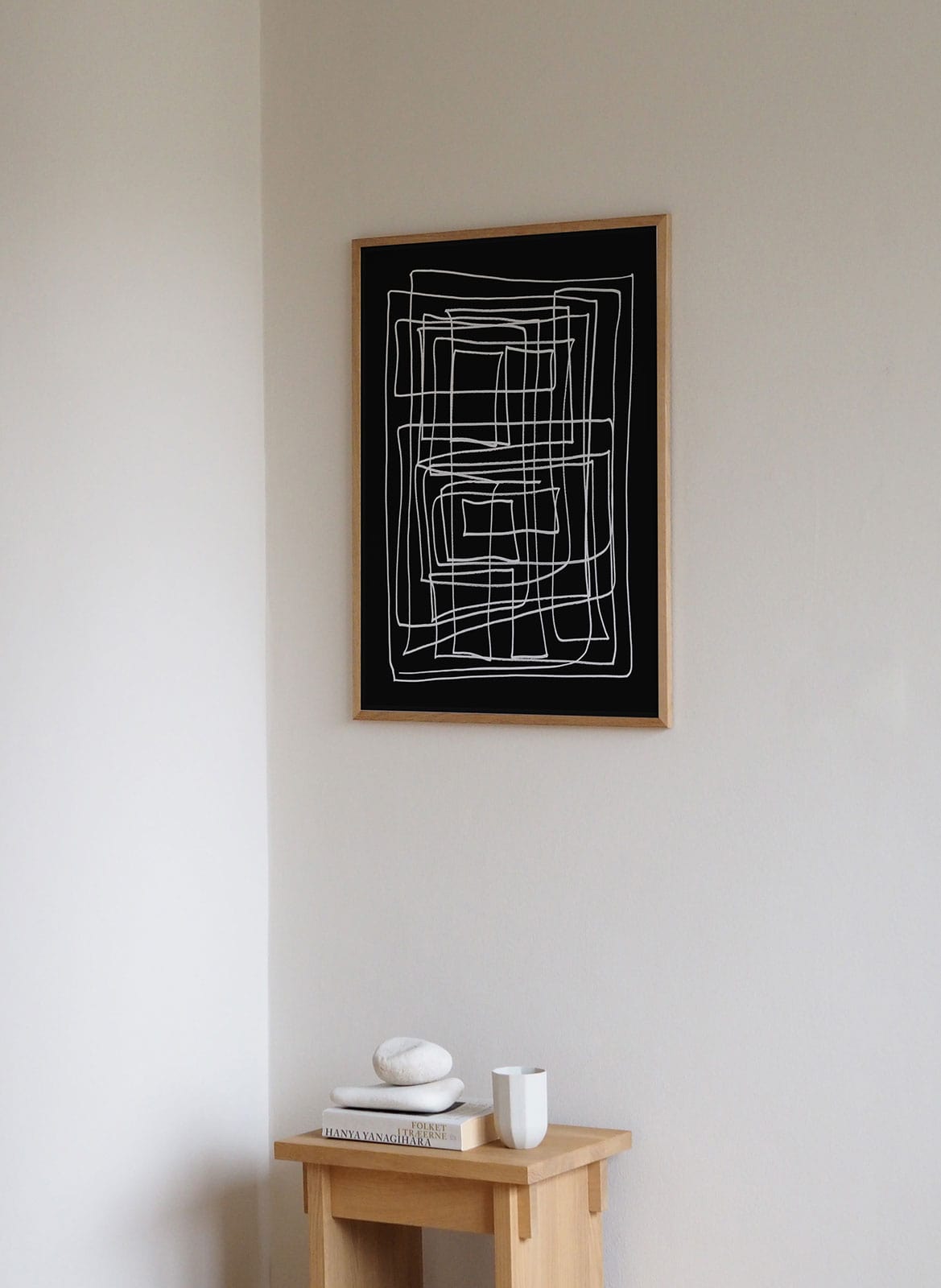 Framed minimalistic poster hanging above bedroom by Atelier Cph