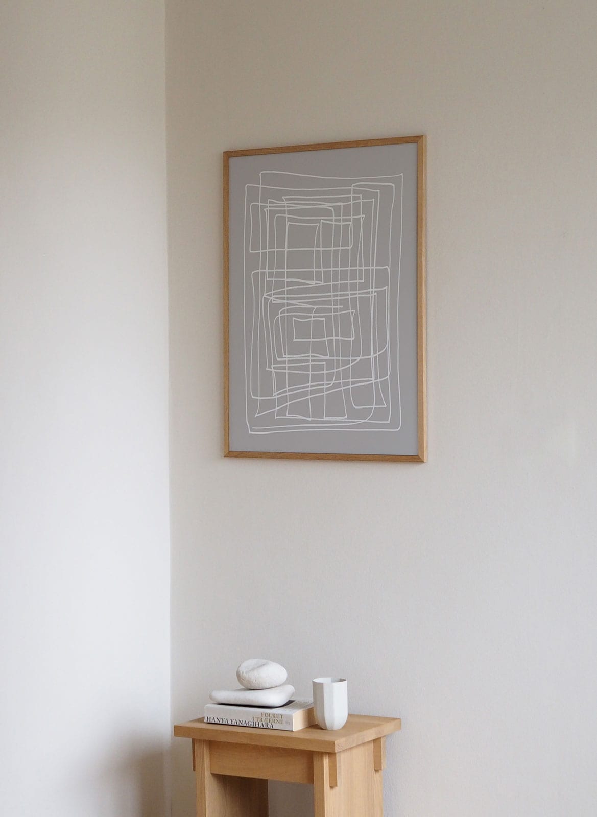 Framed minimalistic posters hanging above a desk/table by Atelier Cph