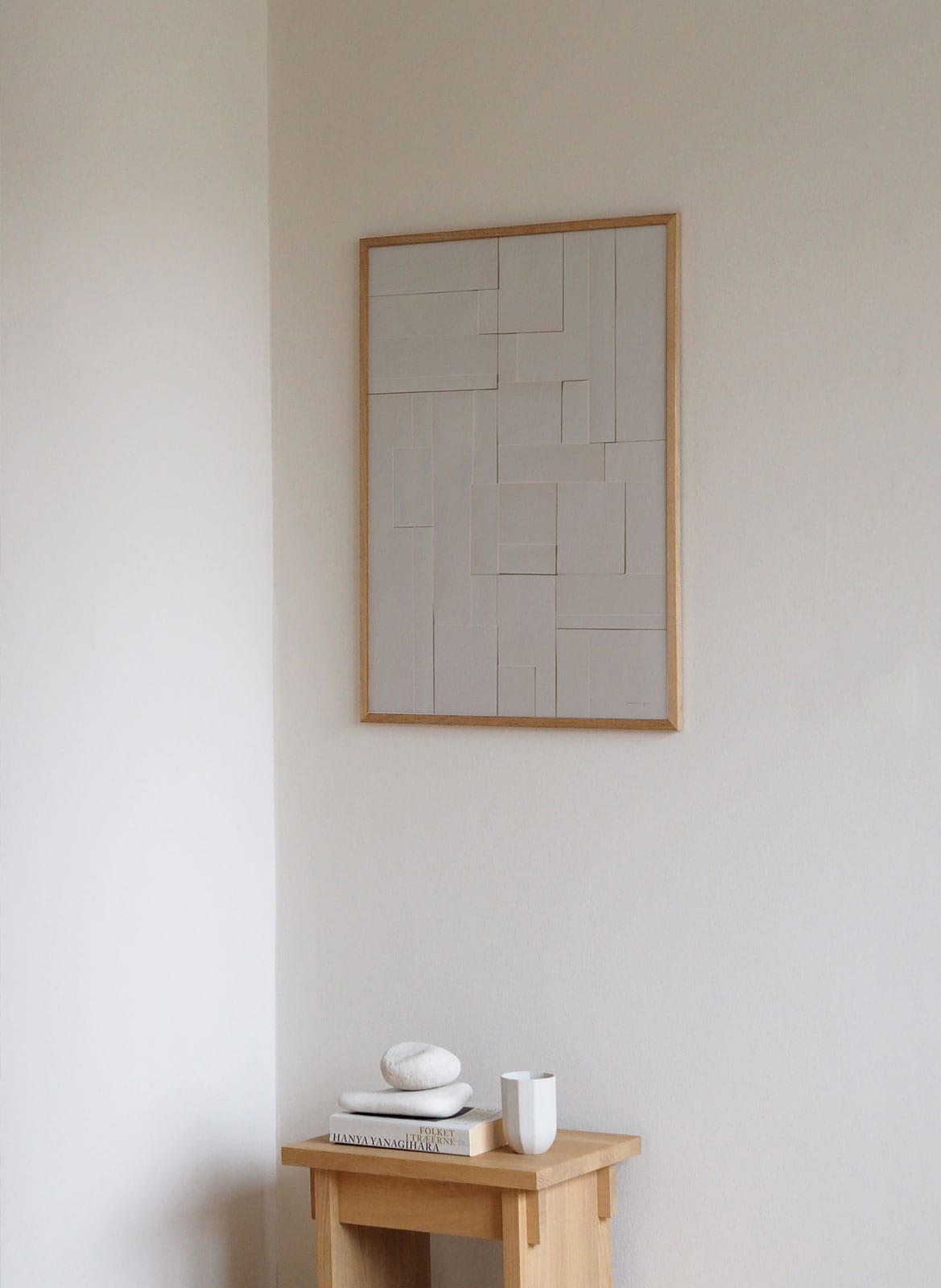Framed minimalistic poster hanging above table by Atelier Cph