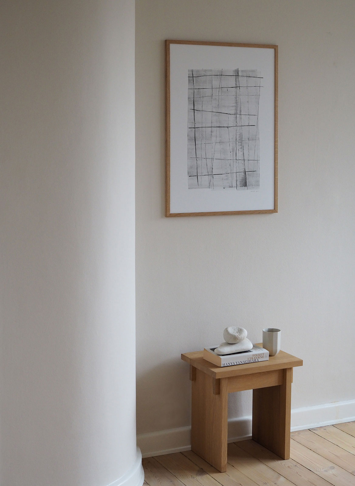 Framed black and white poster hanging above table by Atelier Cph