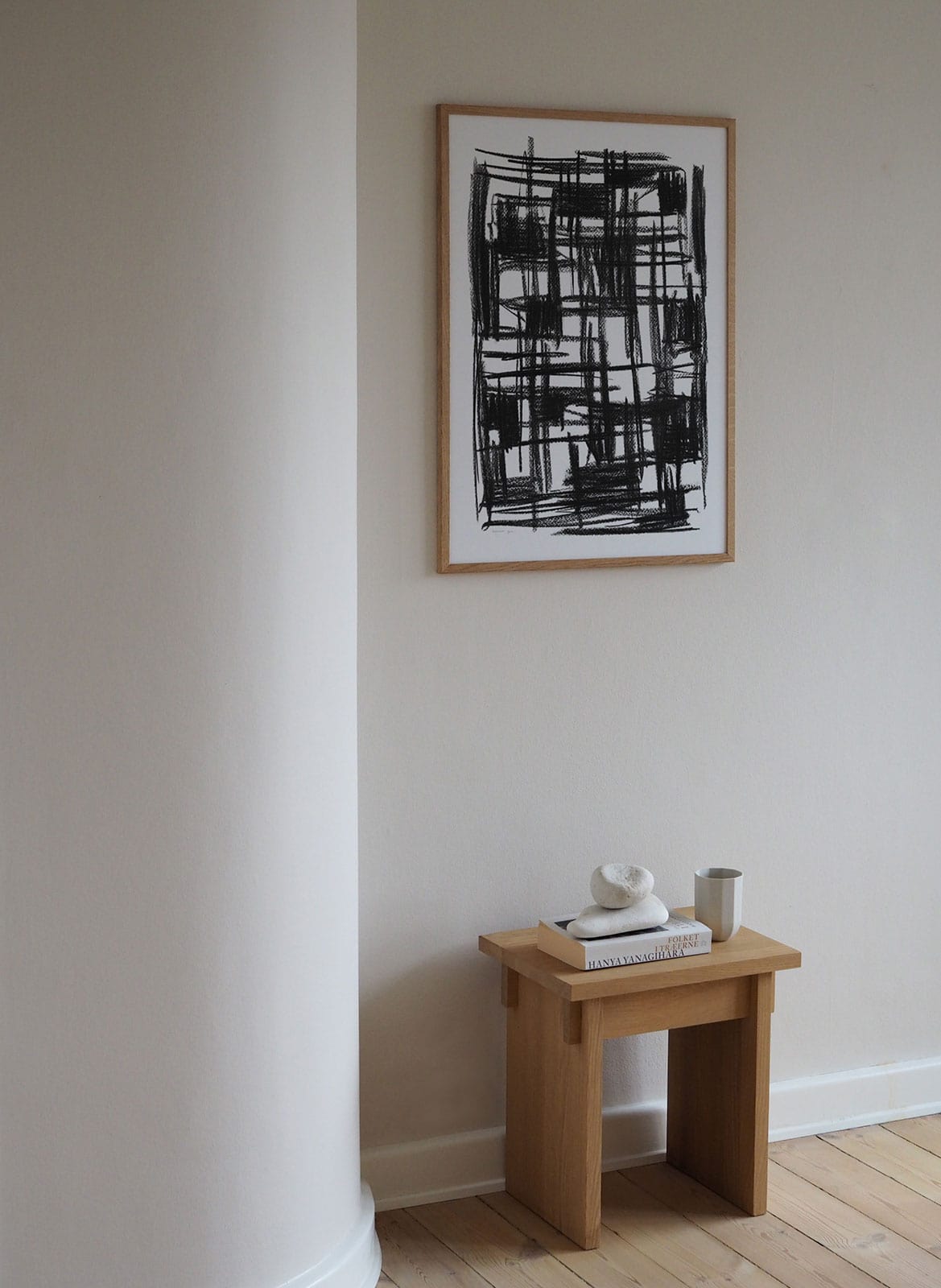 Framed minimalistic poster hanging above a table by Atelier Cph