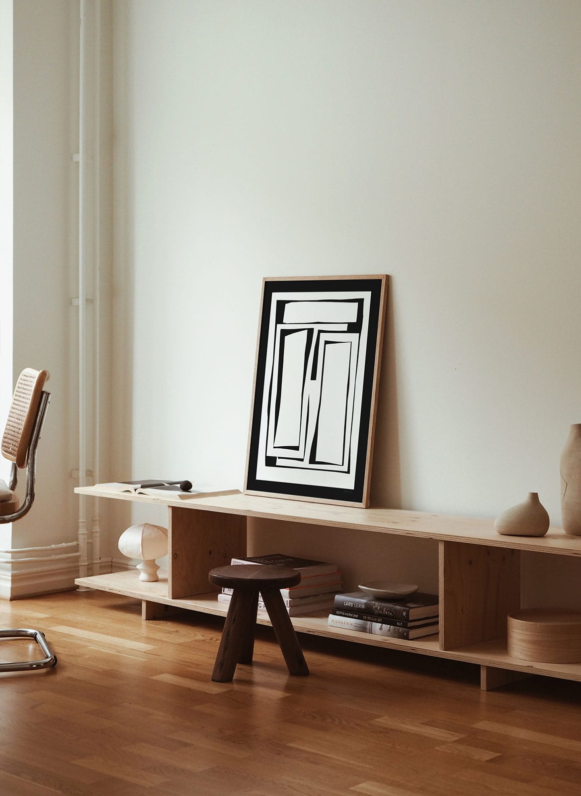 Framed minimalistic poster standing in living room by Atelier Cph