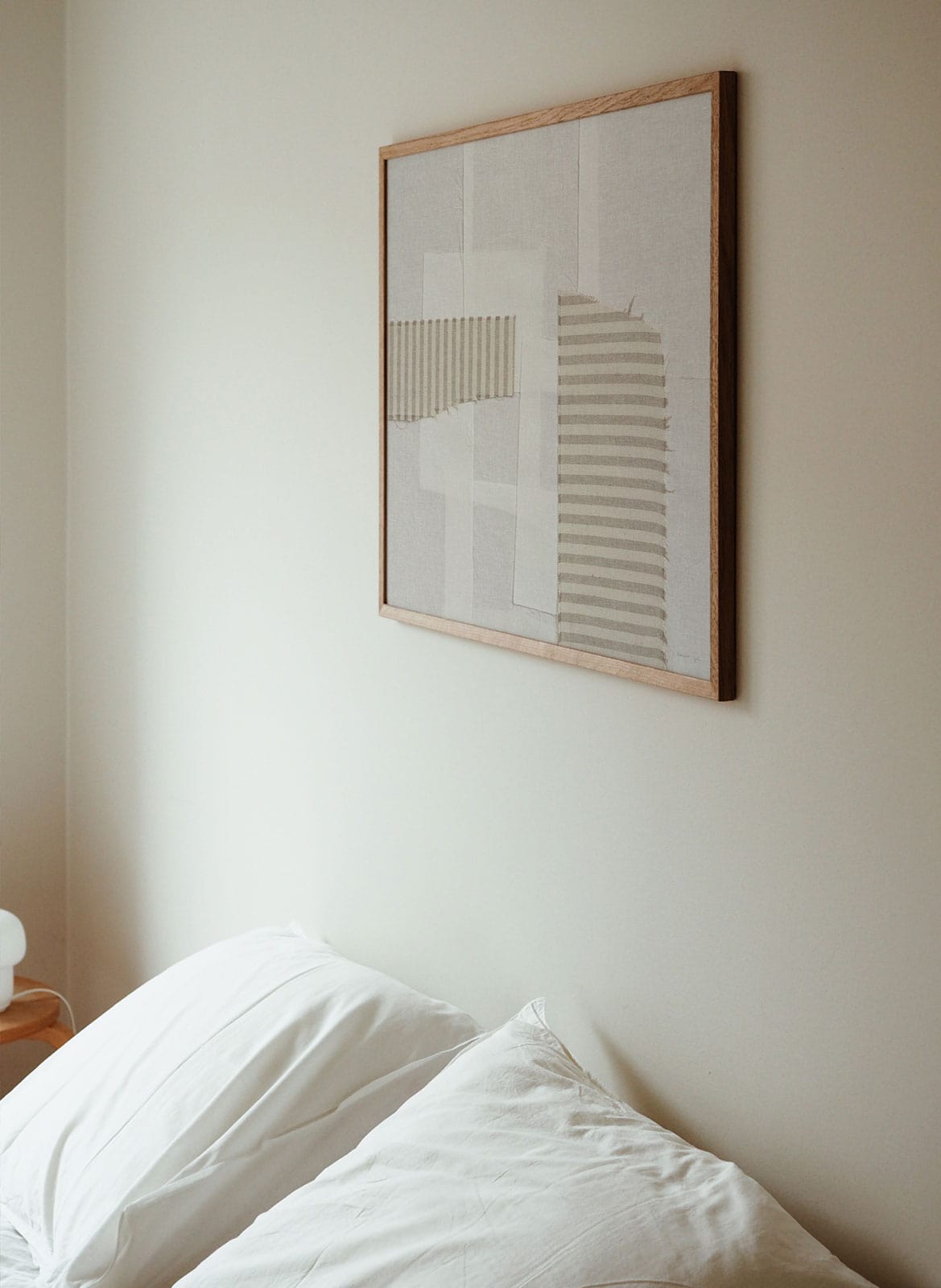 Framed black and white poster hanging in bedroom by Atelier Cph