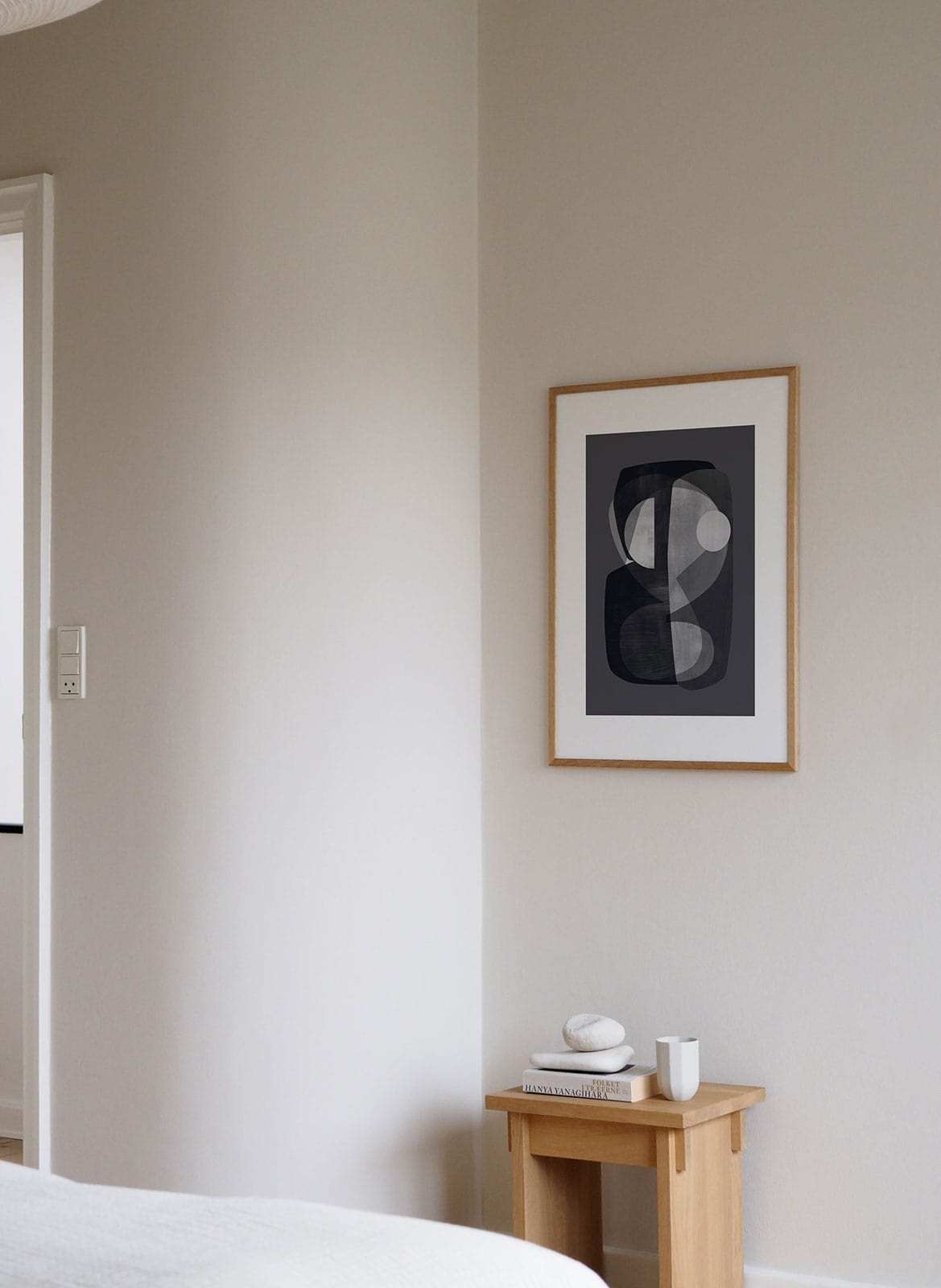Framed grey abstract posters hanging above a table by Atelier Cph