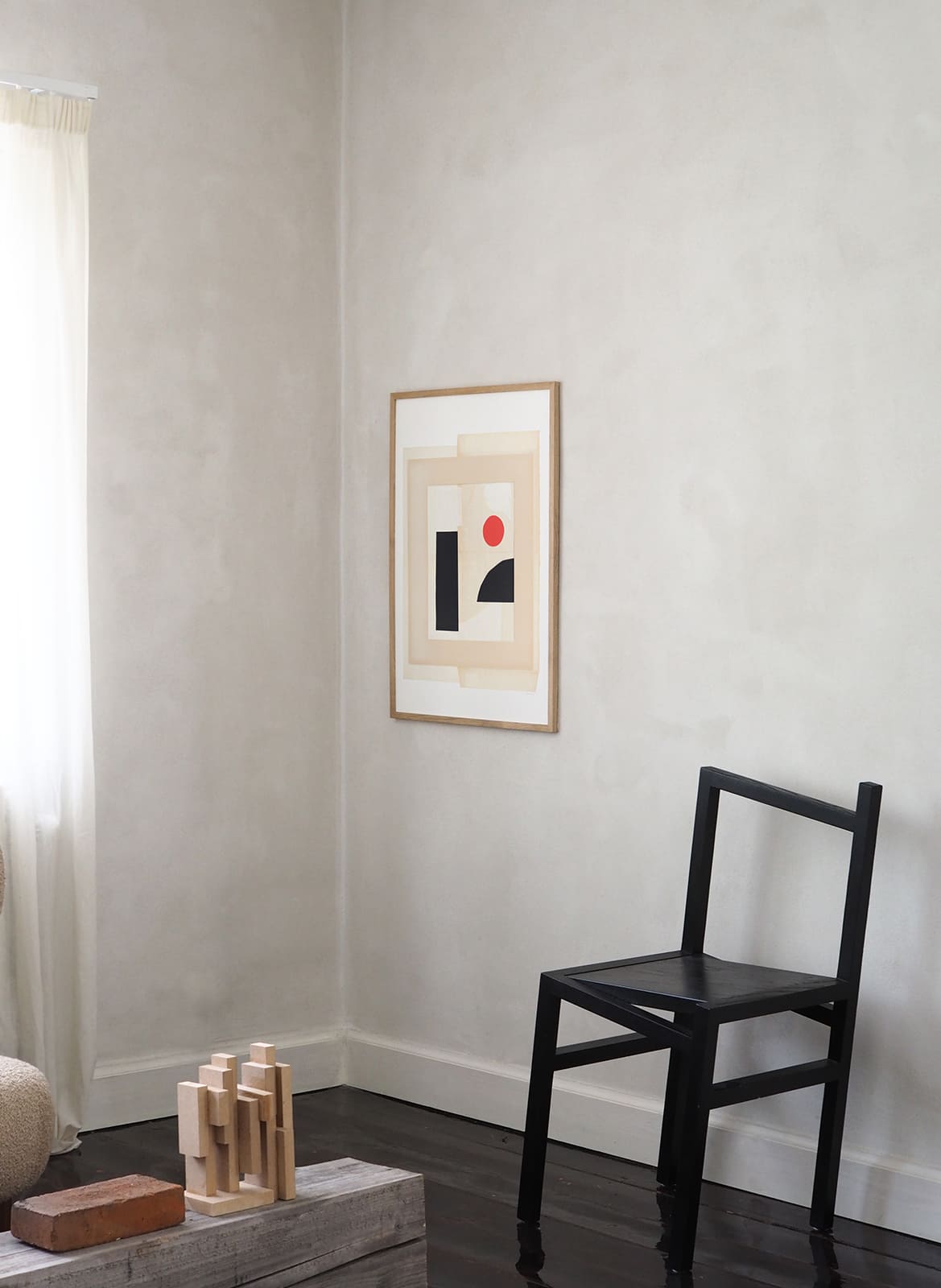 Framed minimalistic poster standing in a living room by Atelier Cph
