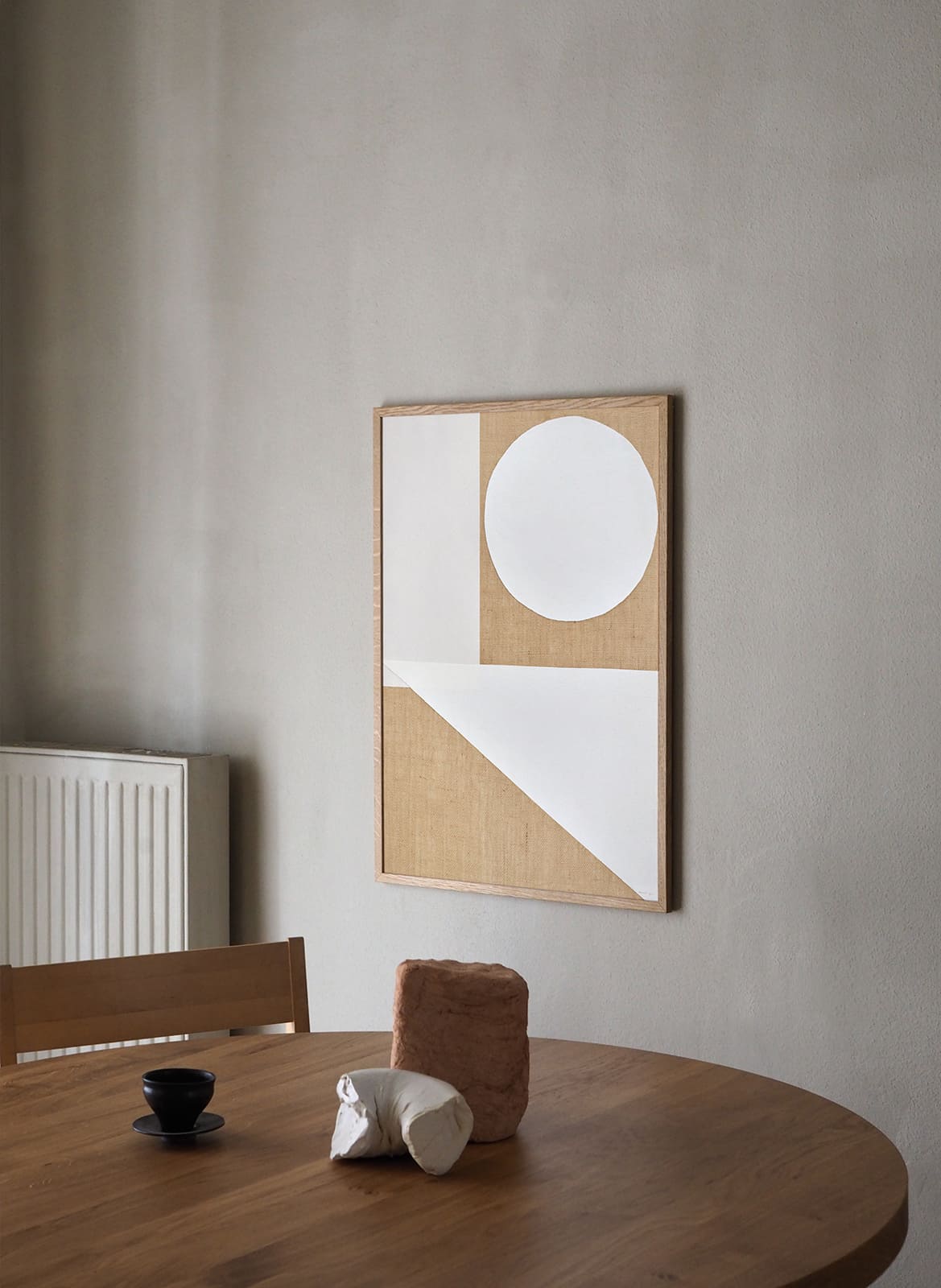  Framed geometrical poster hanging above dining table by Atelier Cph