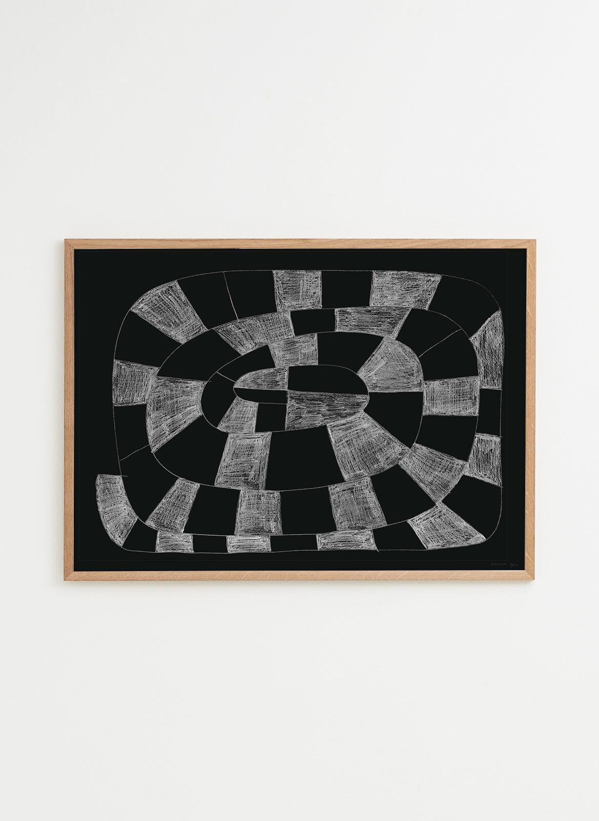 Framed abstract artwork with black and white pattern on a white wall