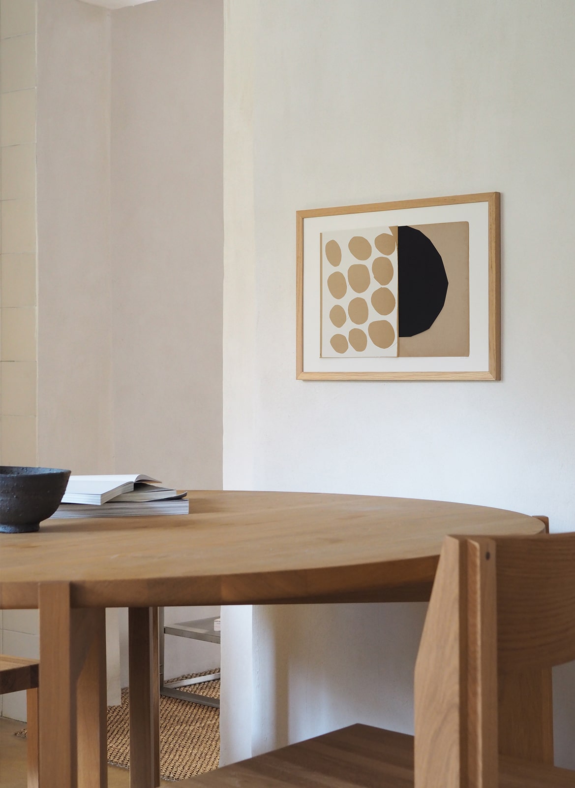 Framed art print with circles hanging above a table by Atelier Cph