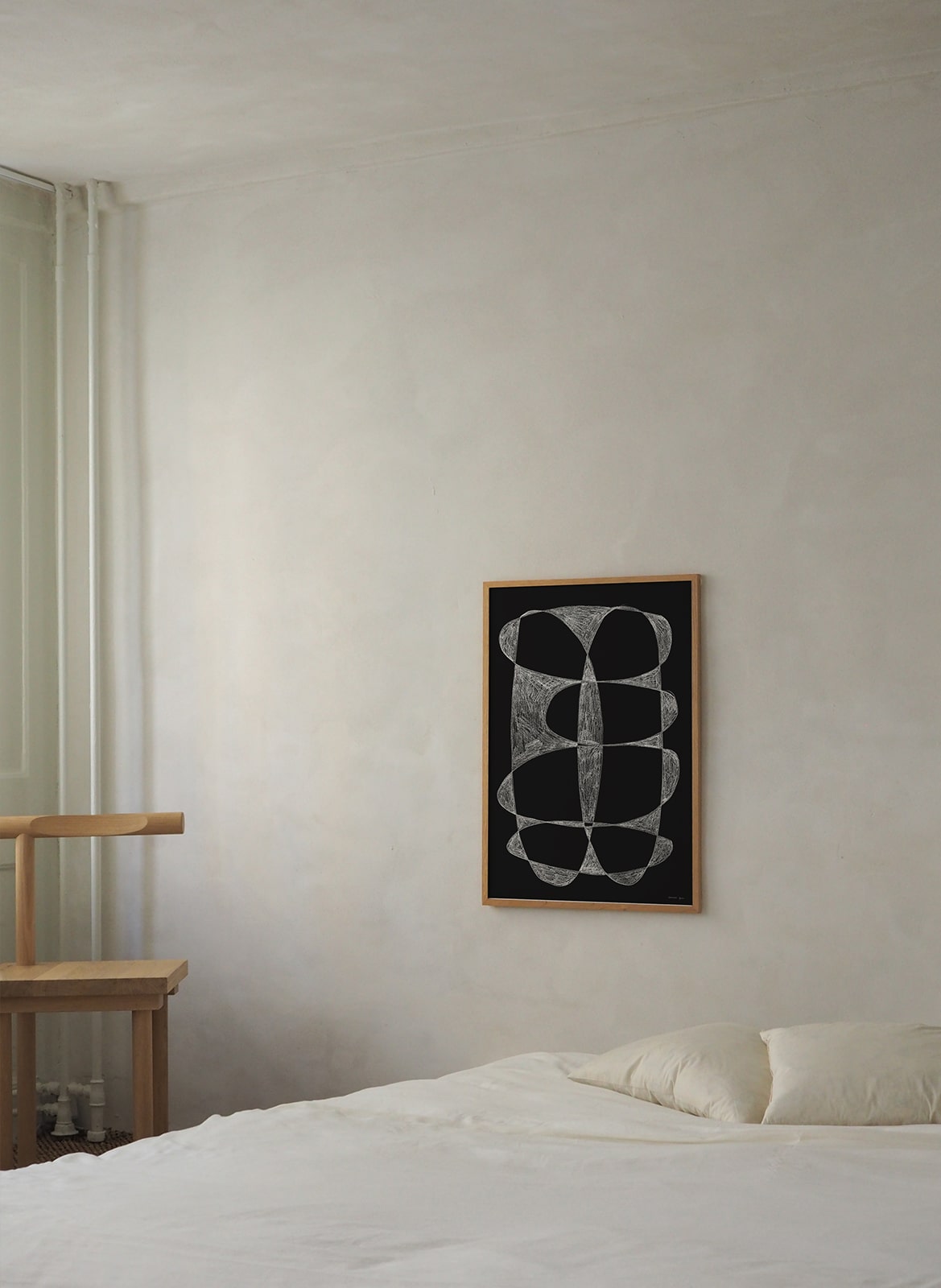 Framed minimalistic poster hanging in a bedroom by Atelier Cph