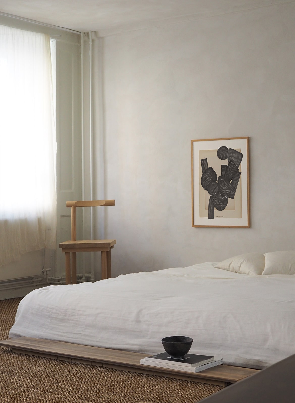 Framed minimalistic poster with graphic elements hanging in bedroom by Atelier Cph