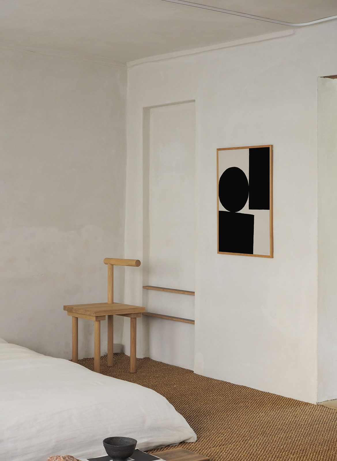 Framed minimalistic poster hanging in a bedroom by Atelier Cph