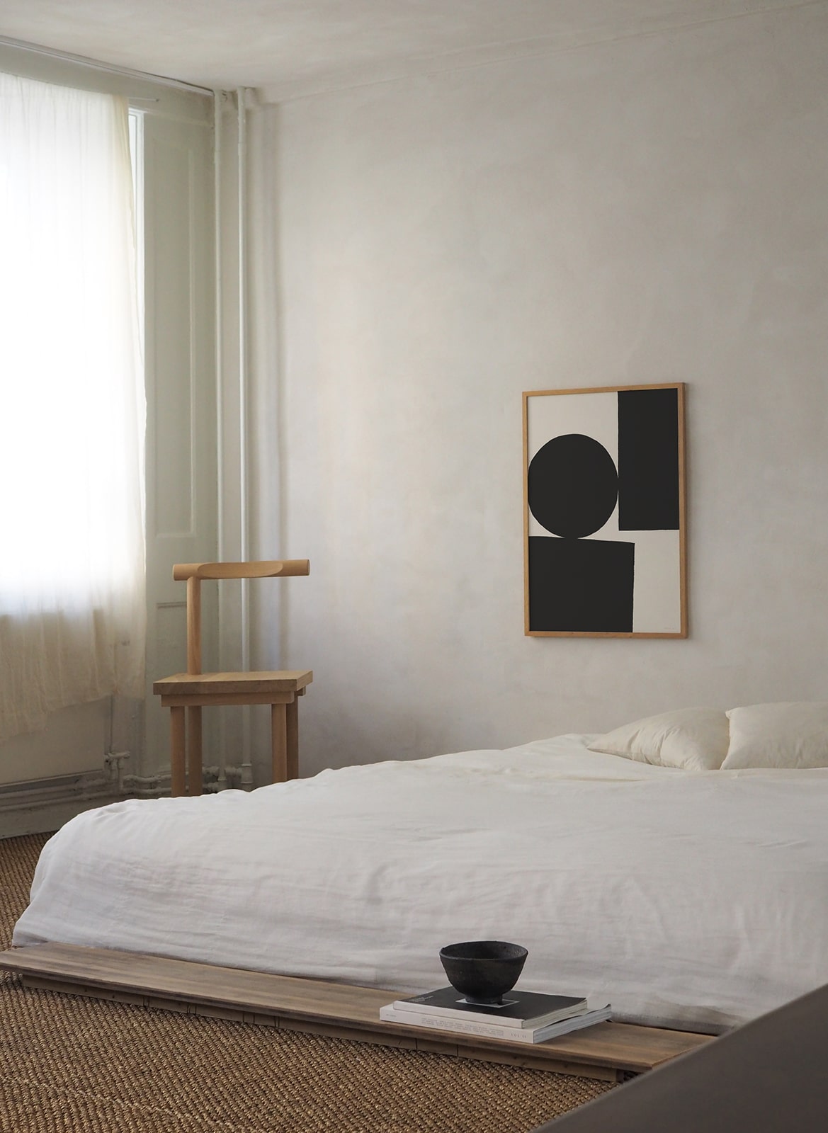 Framed minimalistic poster hanging in a bedroom by Atelier Cph