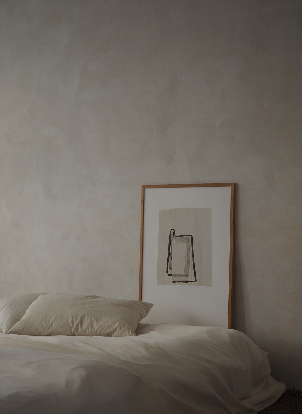 Framed minimalistic poster standing in bedroom by Atelier Cph