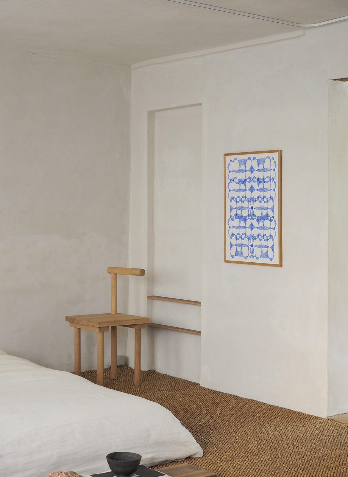 Framed minimalistic poster hanging in a bedroom by Atelier Cph