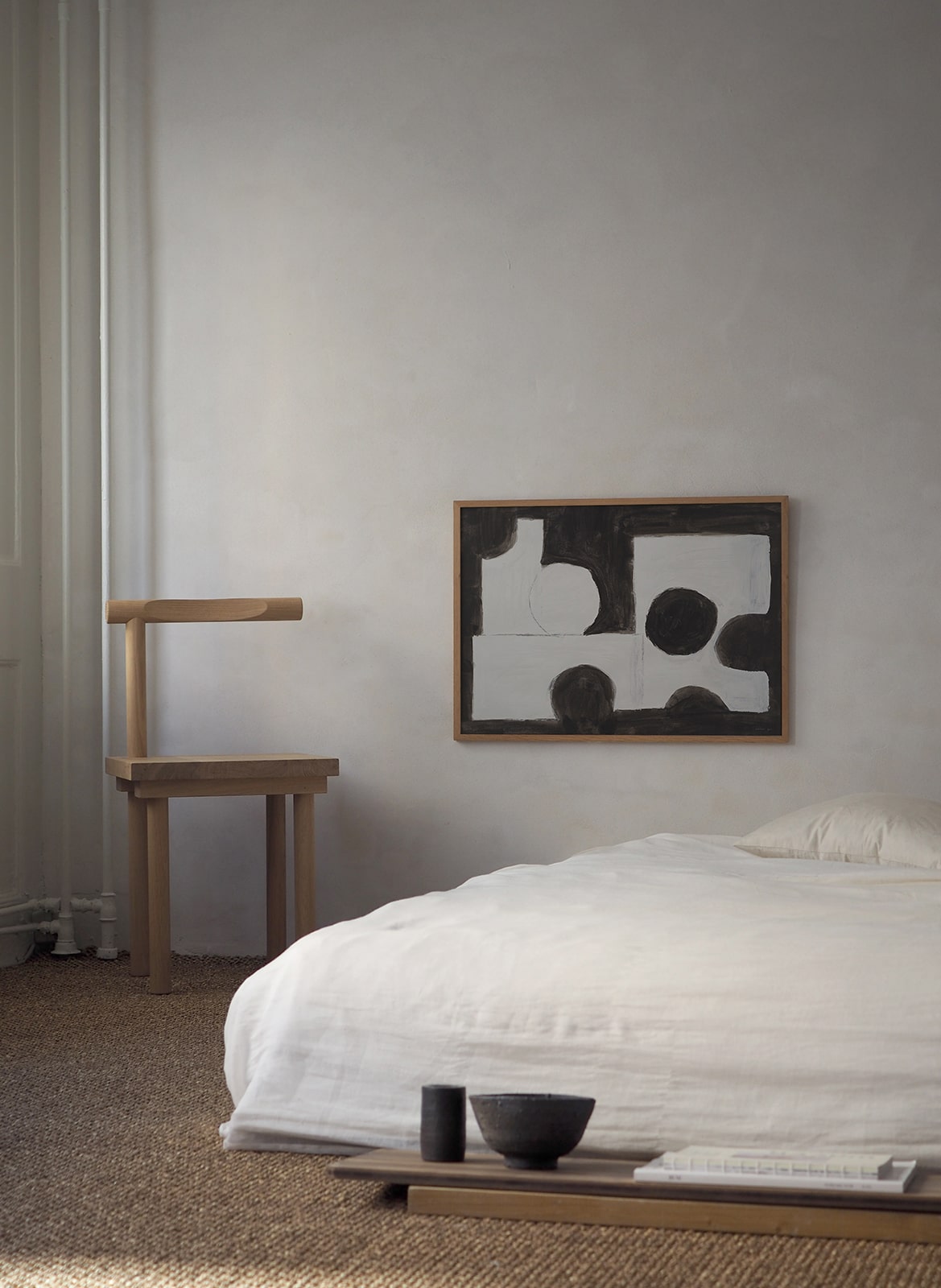 Framed minimalistic poster hanging in a bedroom by Atelier Cph